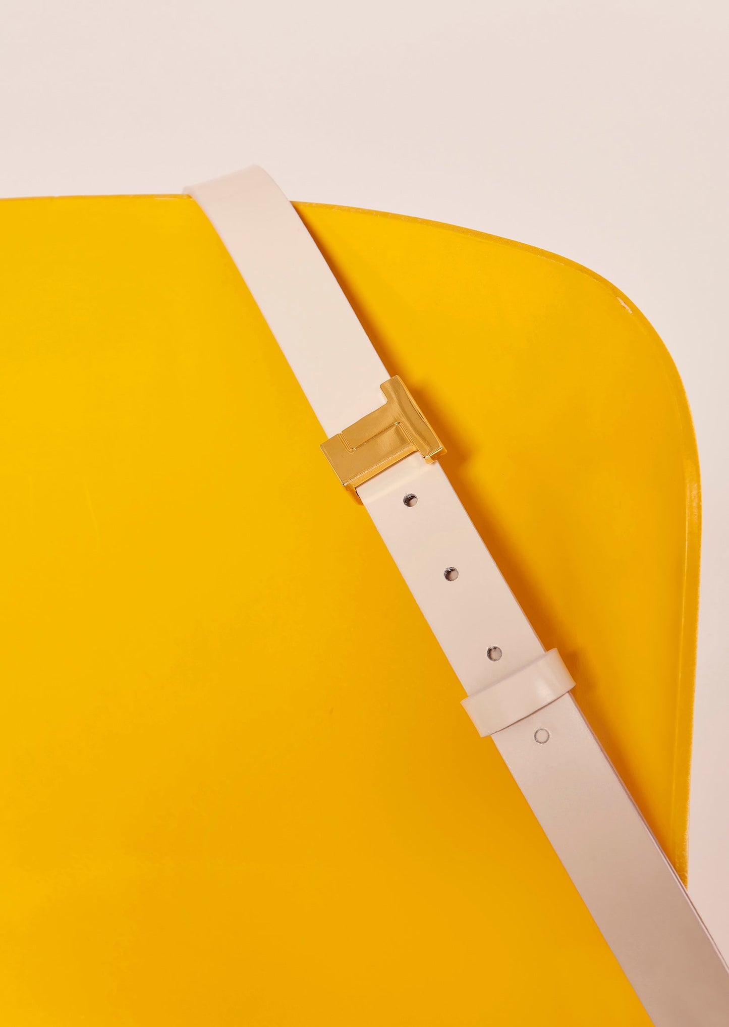 White leather belt with gold buckle.