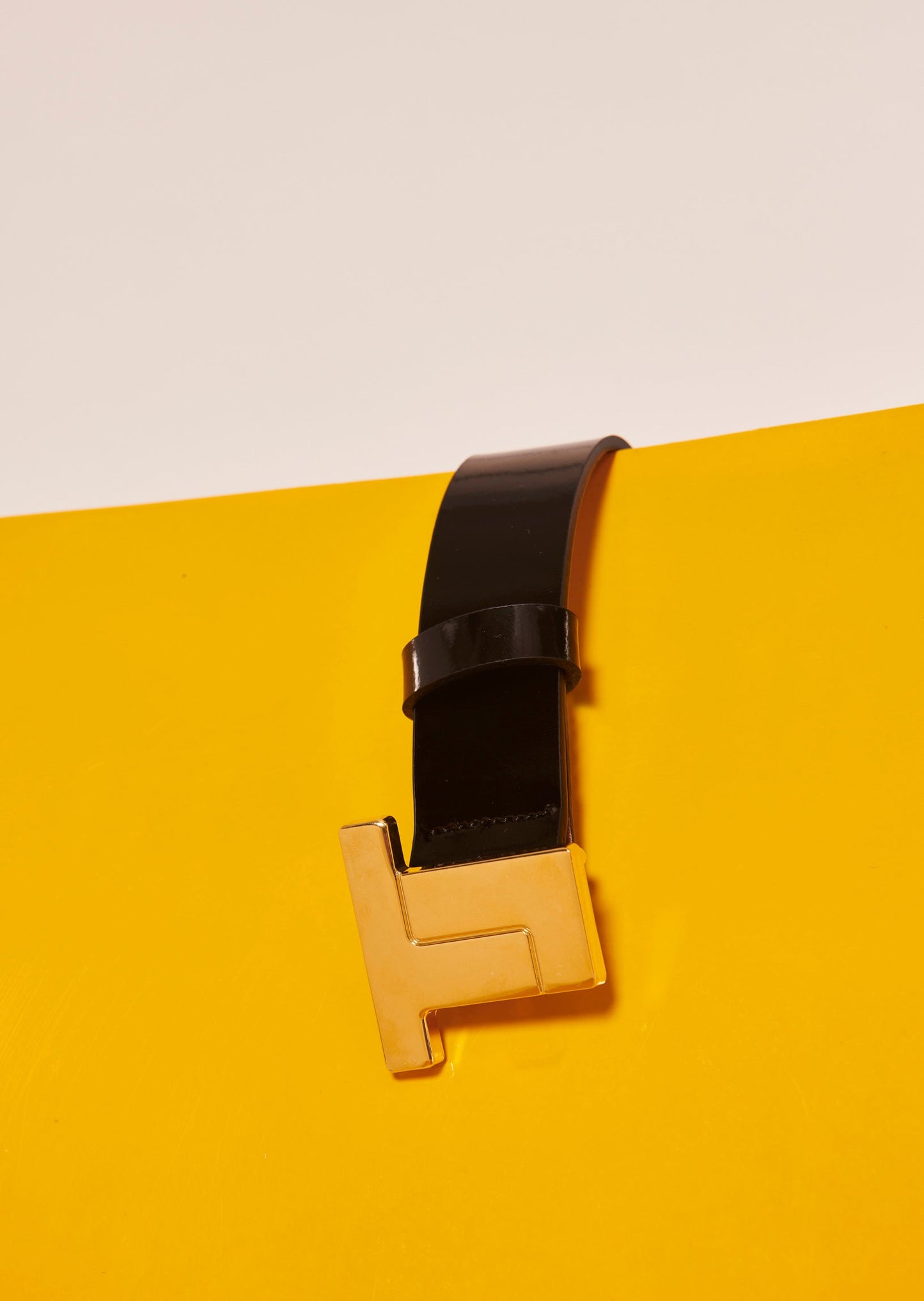 Black leather belt with gold buckle.