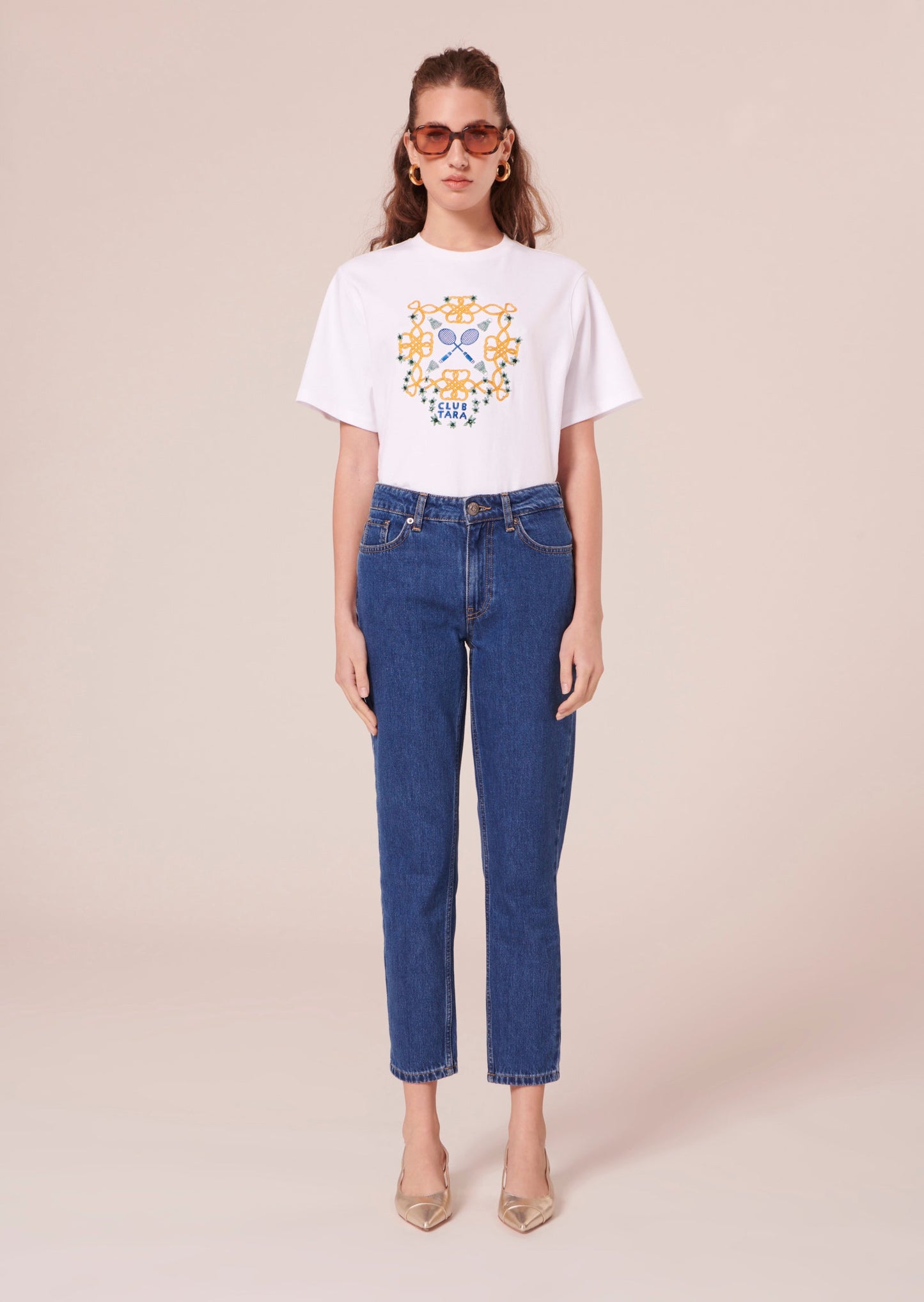 Blue denim jeans matching with white t-shirt and gold leather pumps.