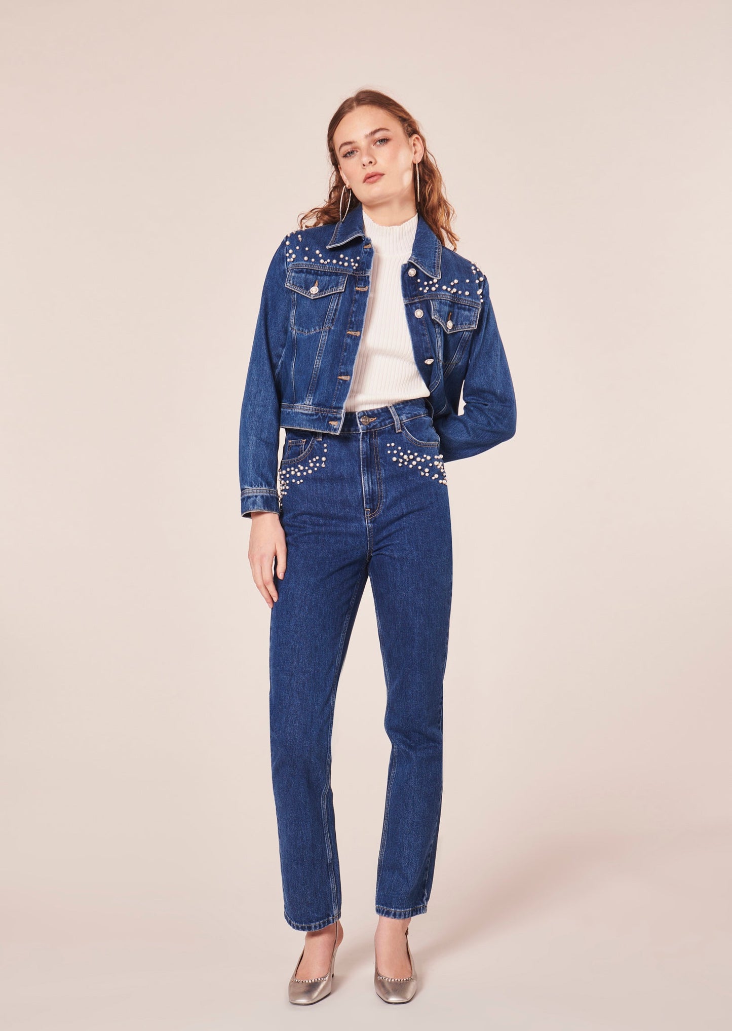 Model wearing Tara Jarmon straight cut blue denim jeans with embroidered pearls and rhinestones, matching with a blue denim jacket.