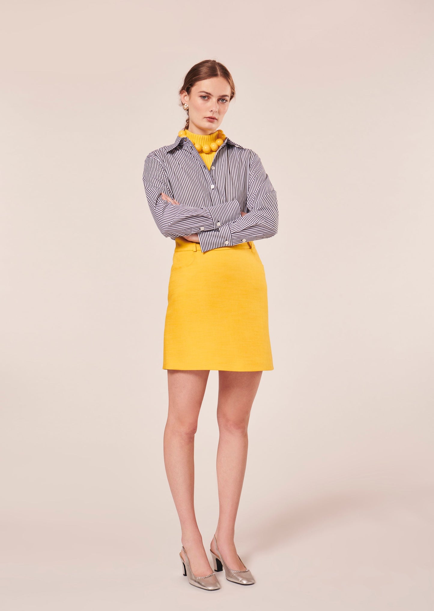 Model wearing Tara Jarmon Yellow Flared Skirt with Belt Loops and Side Pockets.