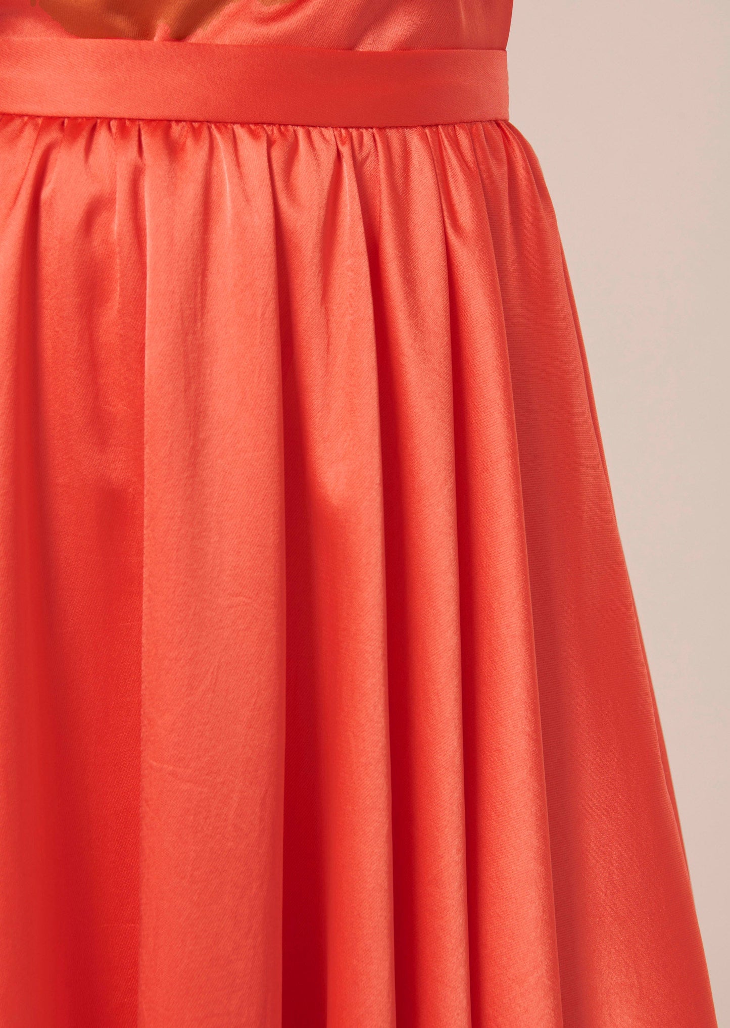 Long flowing coral satin skirt.