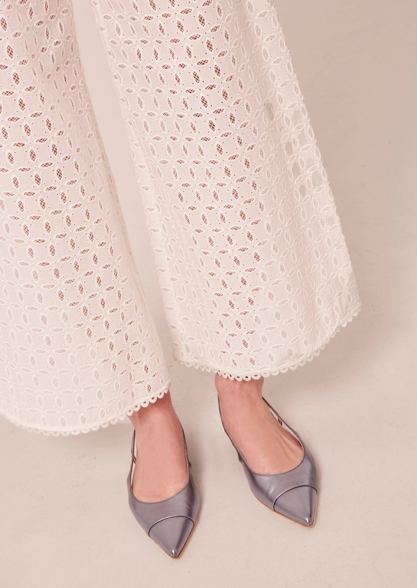 Embroidered white high waist pants matched with blue metallic leather pumps.