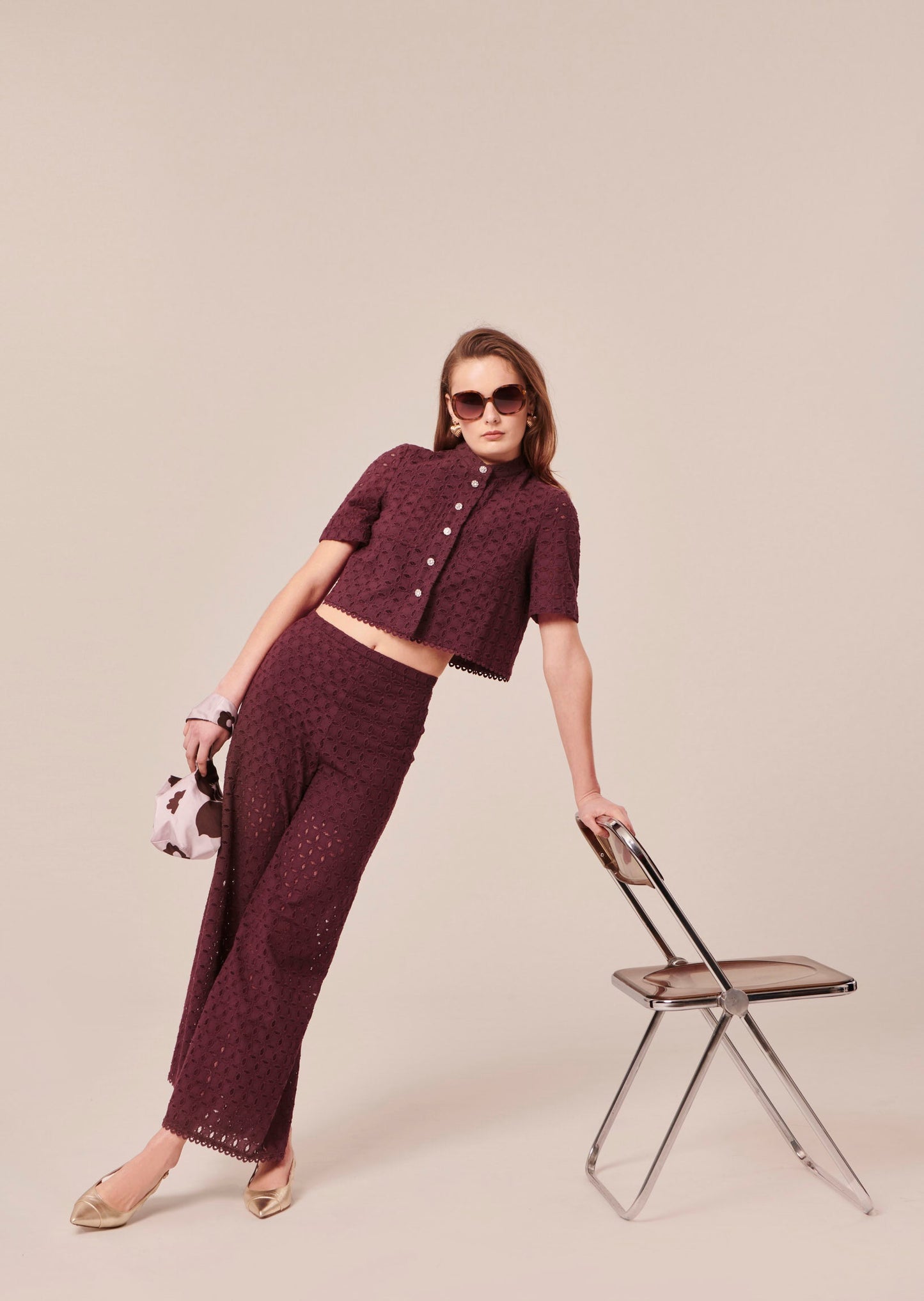 Model wearing Tara Jarmon chocolate-colored high-waisted pants.