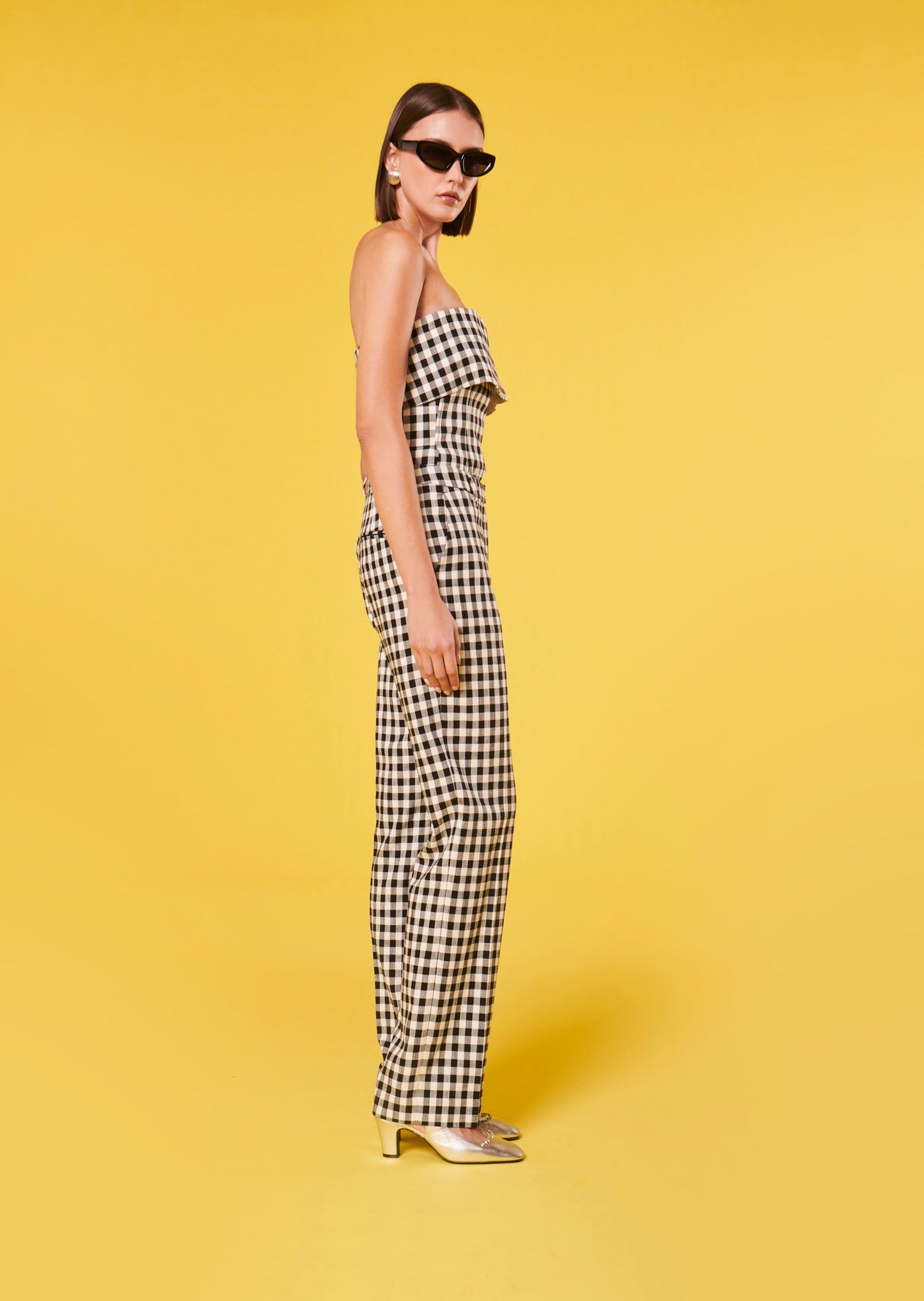 Model wearing Tara Jarmon black gingham pants with matching sleeveless top.