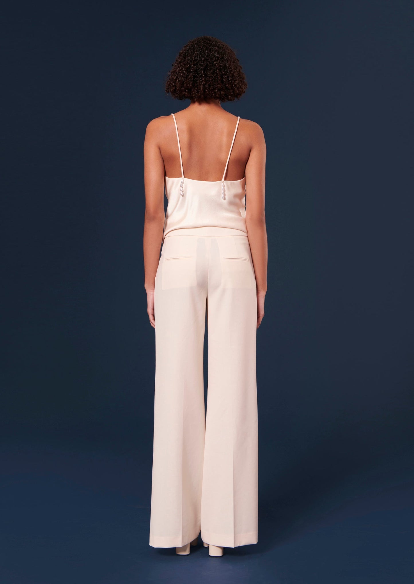 Off-white pants with welt pockets on the back.