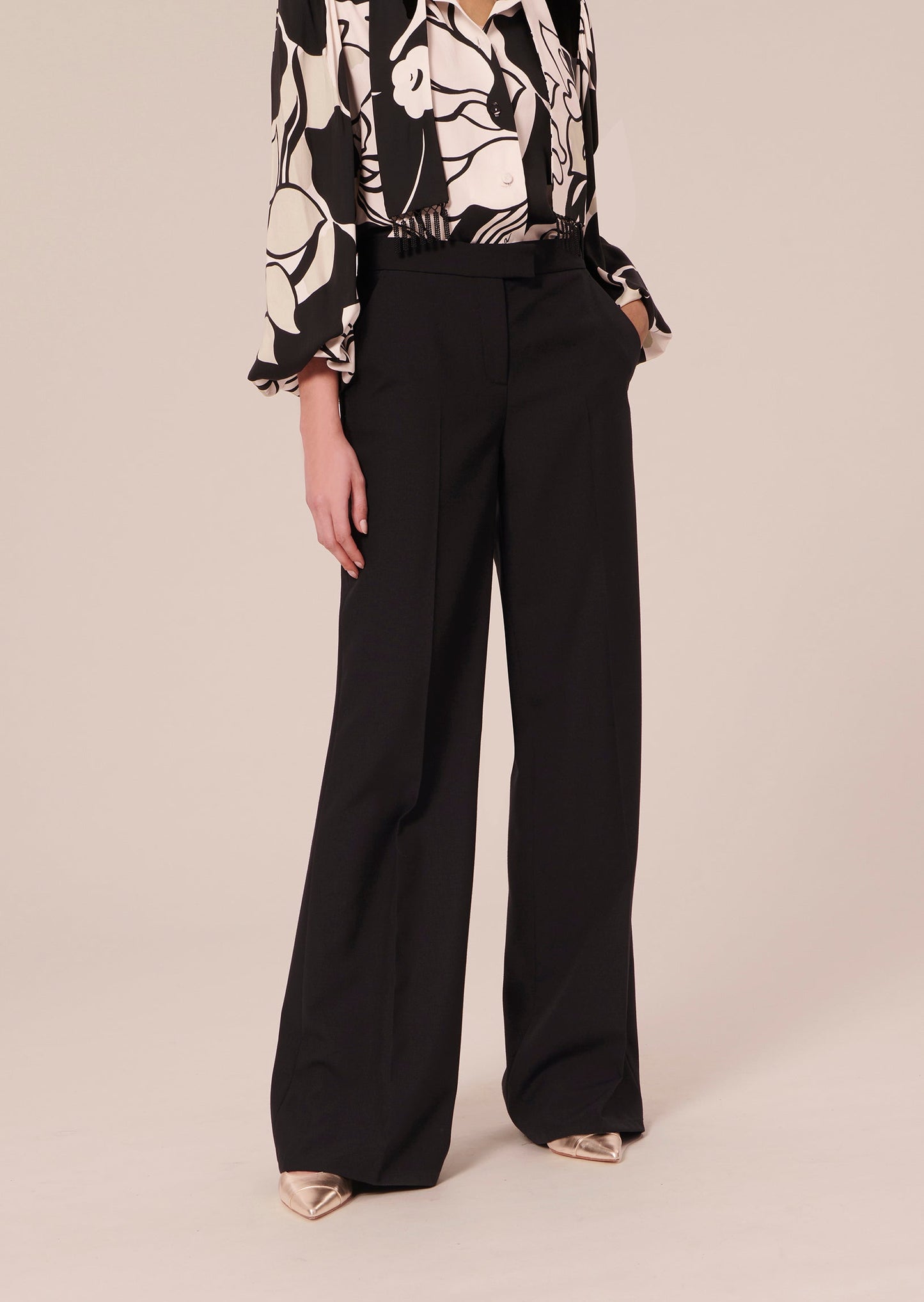 Black pants with wide, flared cut and a flat pleat.