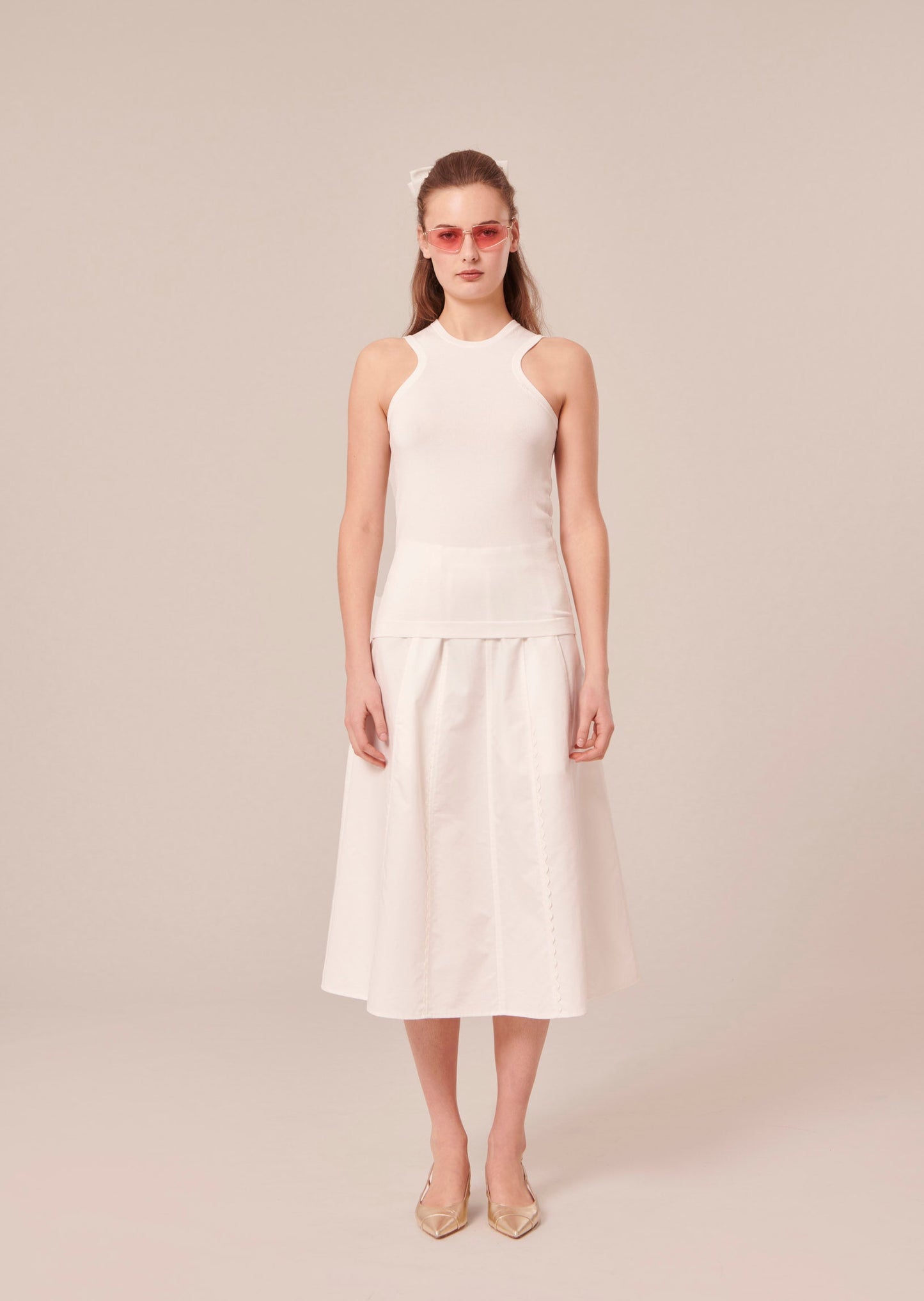 Model wearing Tara Jarmon off-white sleeveless pull.