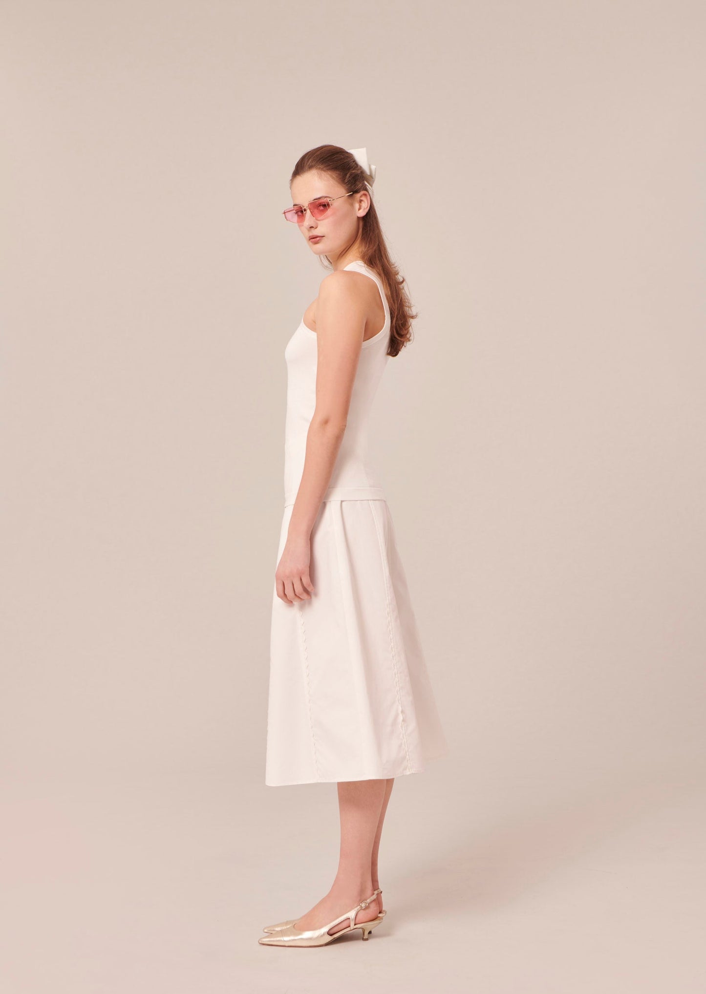 Off-white sleeveless top with matching flowing skirt.