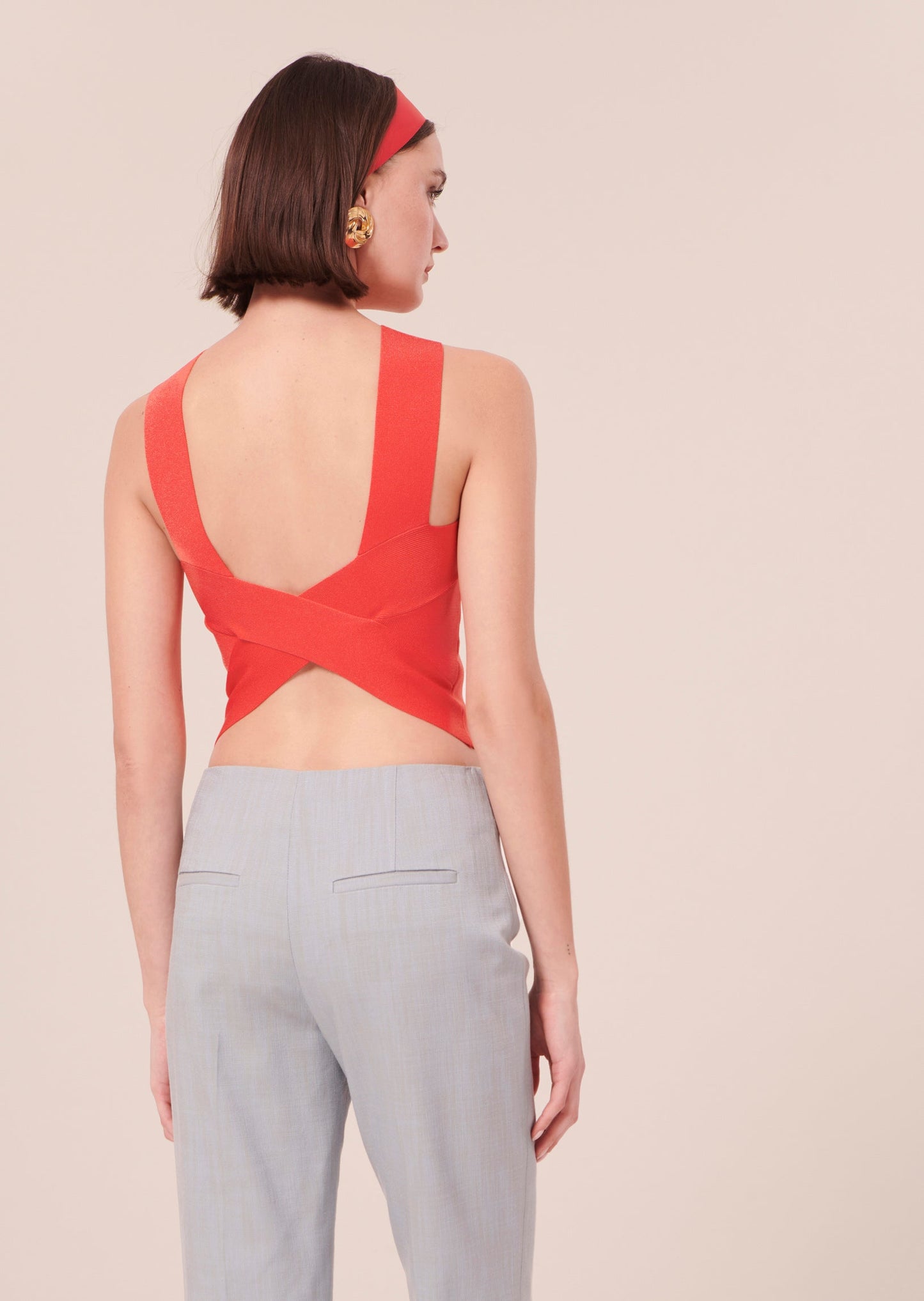 Coral crop top with elegant revealing back and high waist denim pants.