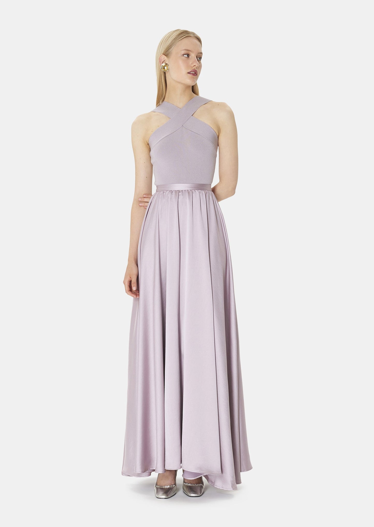 Model wearing Tara Jarmon mauve colored crop top that crosses at the front and back with long satin light purple skirt.