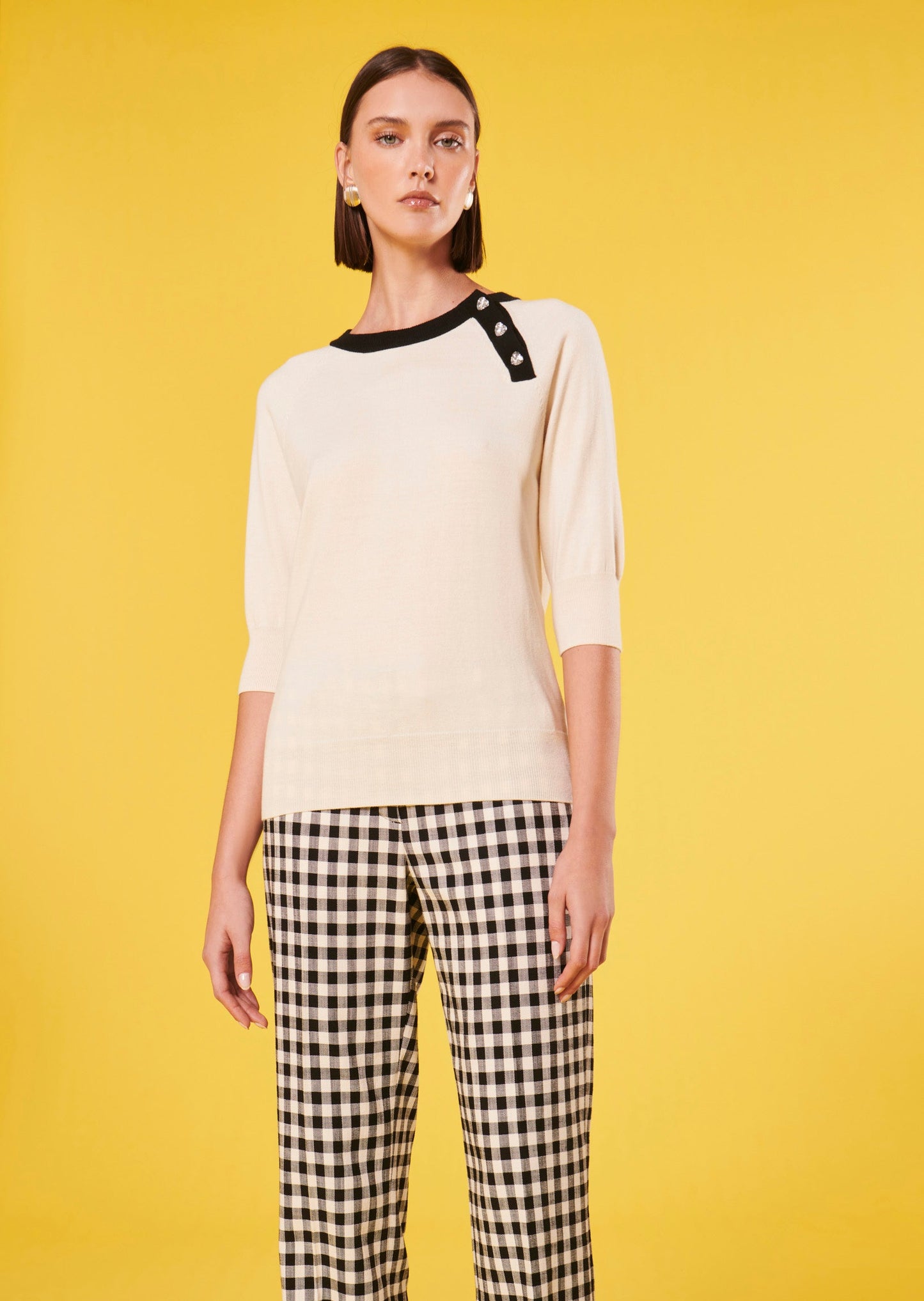 Model wearing Tara Jarmon ecru sweater with a round neck and short sleeves.