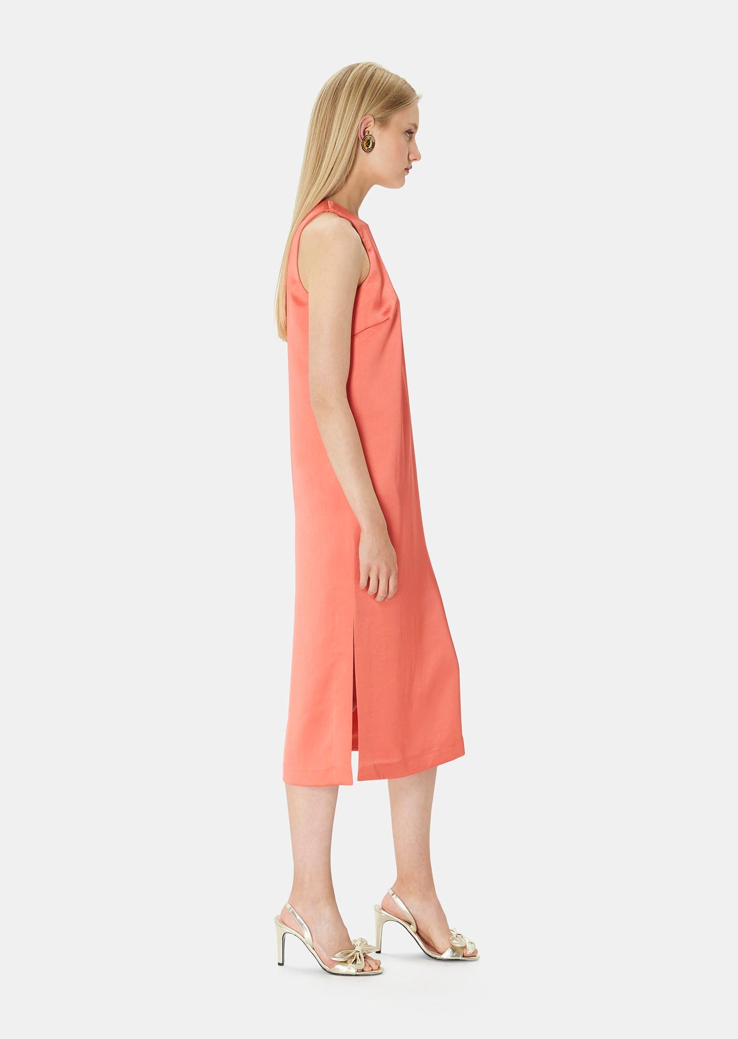 Model wearing Tara Jarmon sleeveless, long coral satin dress.