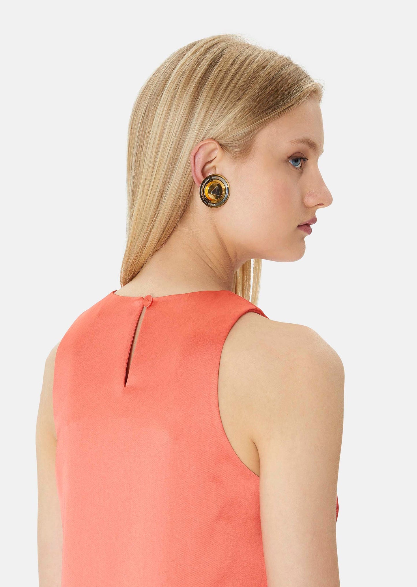 Straight, flowing cut, satin coral dress with a tone-on-tone button at the nape of the neck.