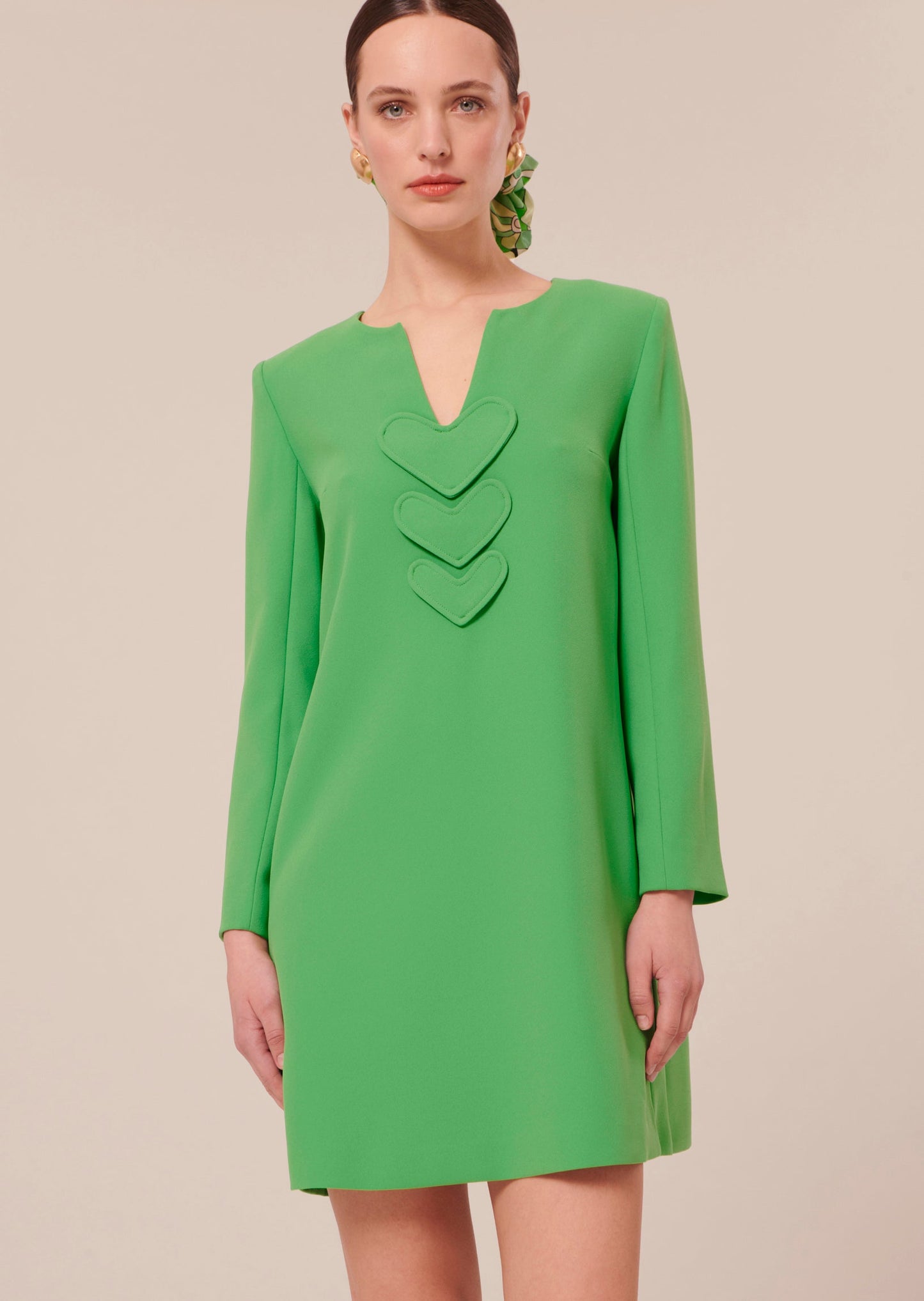 Long sleeves, short green dress with V-neckline.