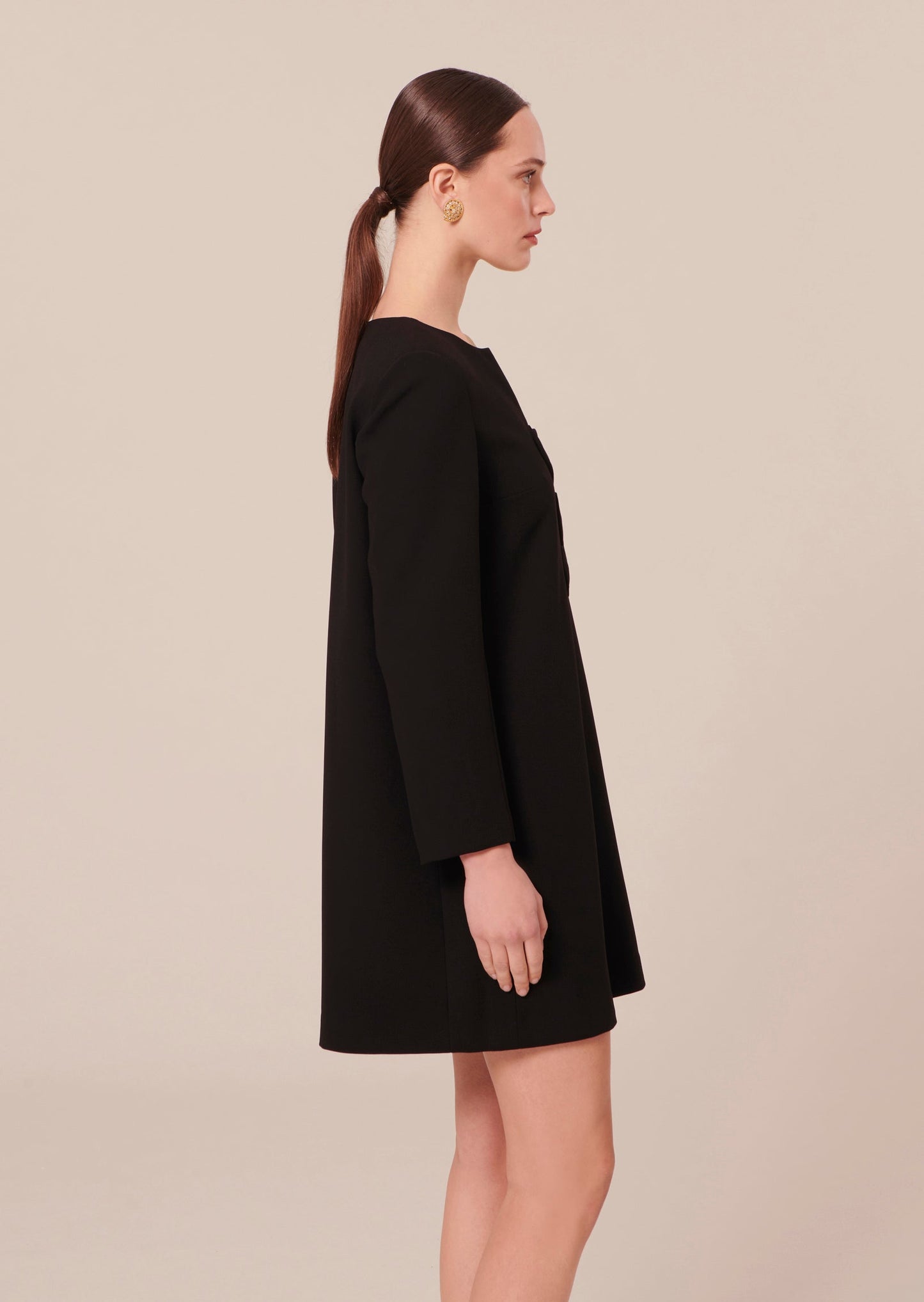 Straight cut, black crepe dress with v-neckline.