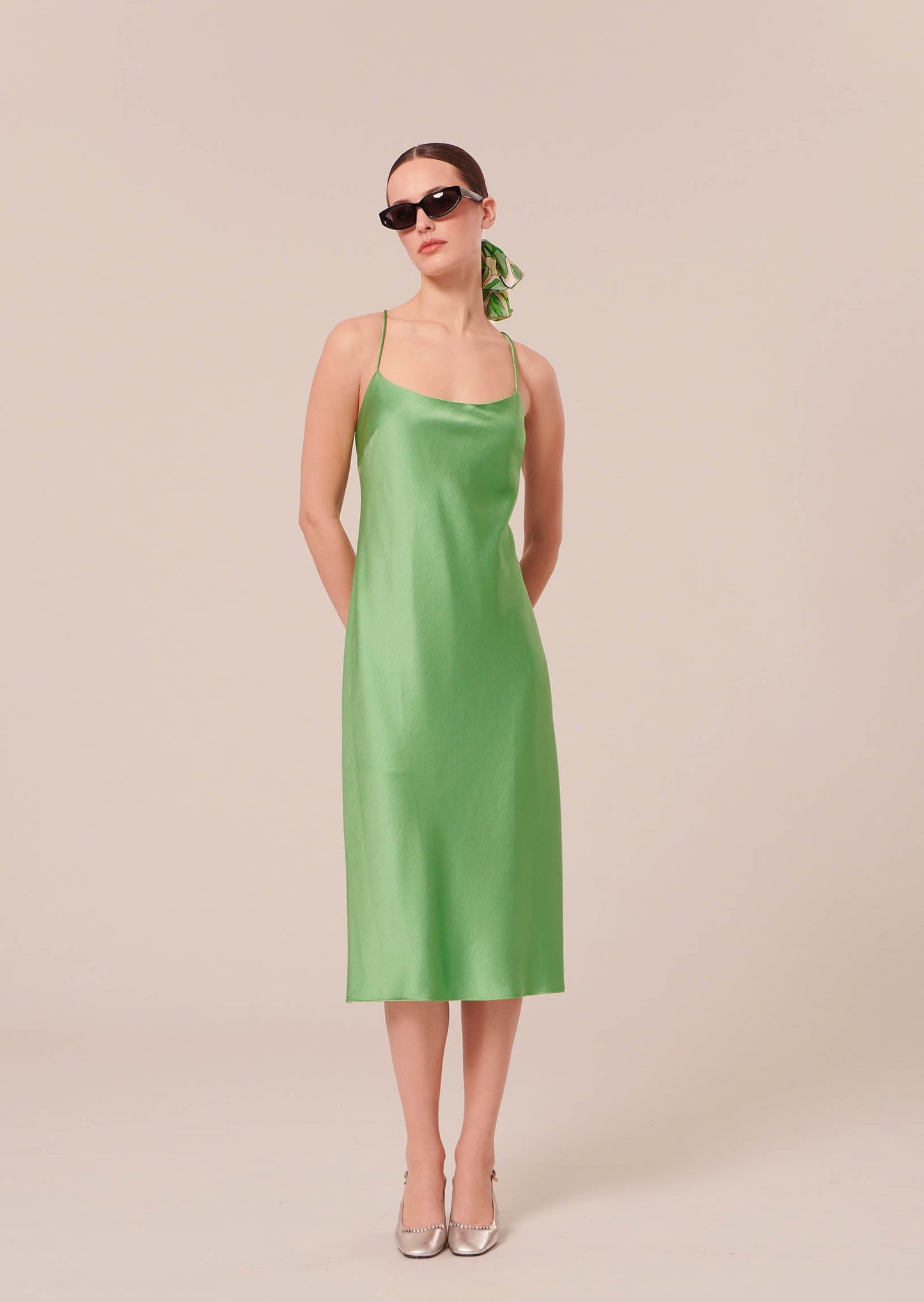 Model wearing Tara Jarmon Green Satin Dress with Cross-Back Straps and Side Slit.