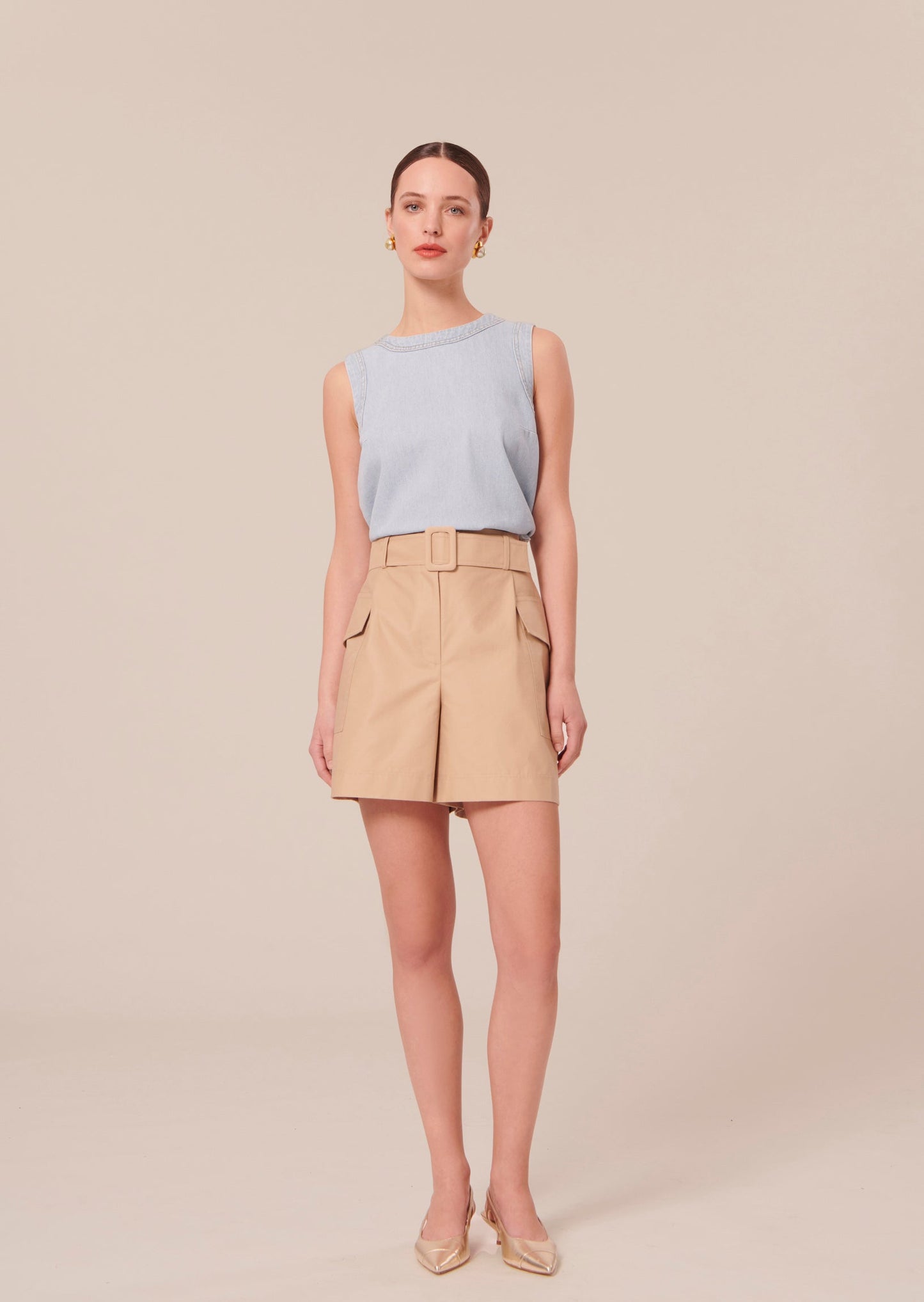 Model wearing Tara Jarmon Beige shorts with two flap pockets.