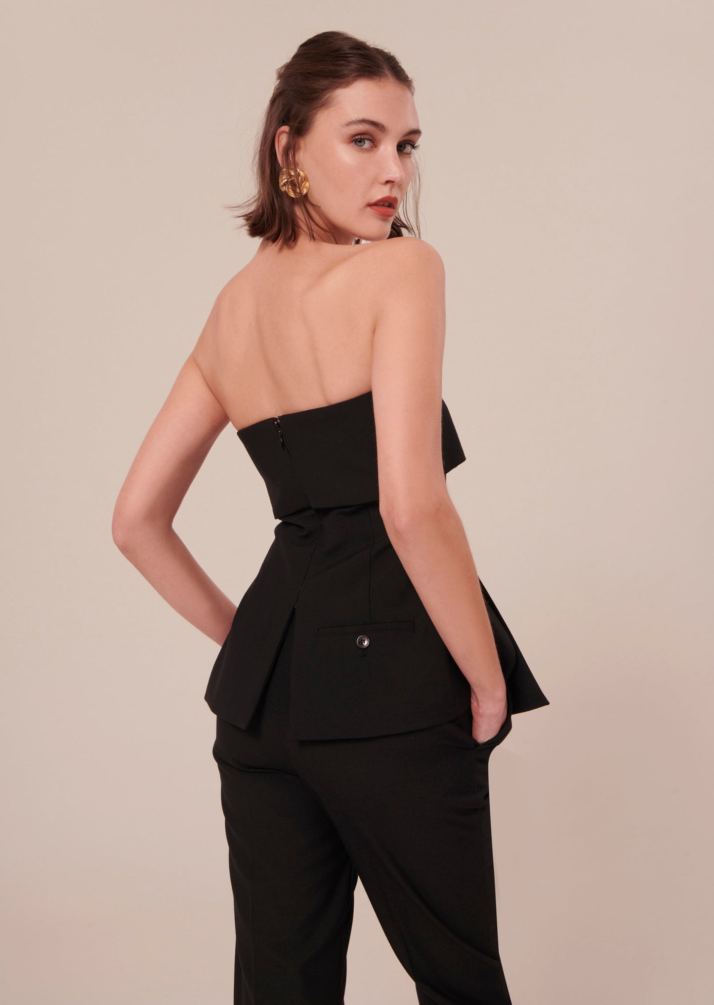 Strapless black top with a welt pocket at the back.