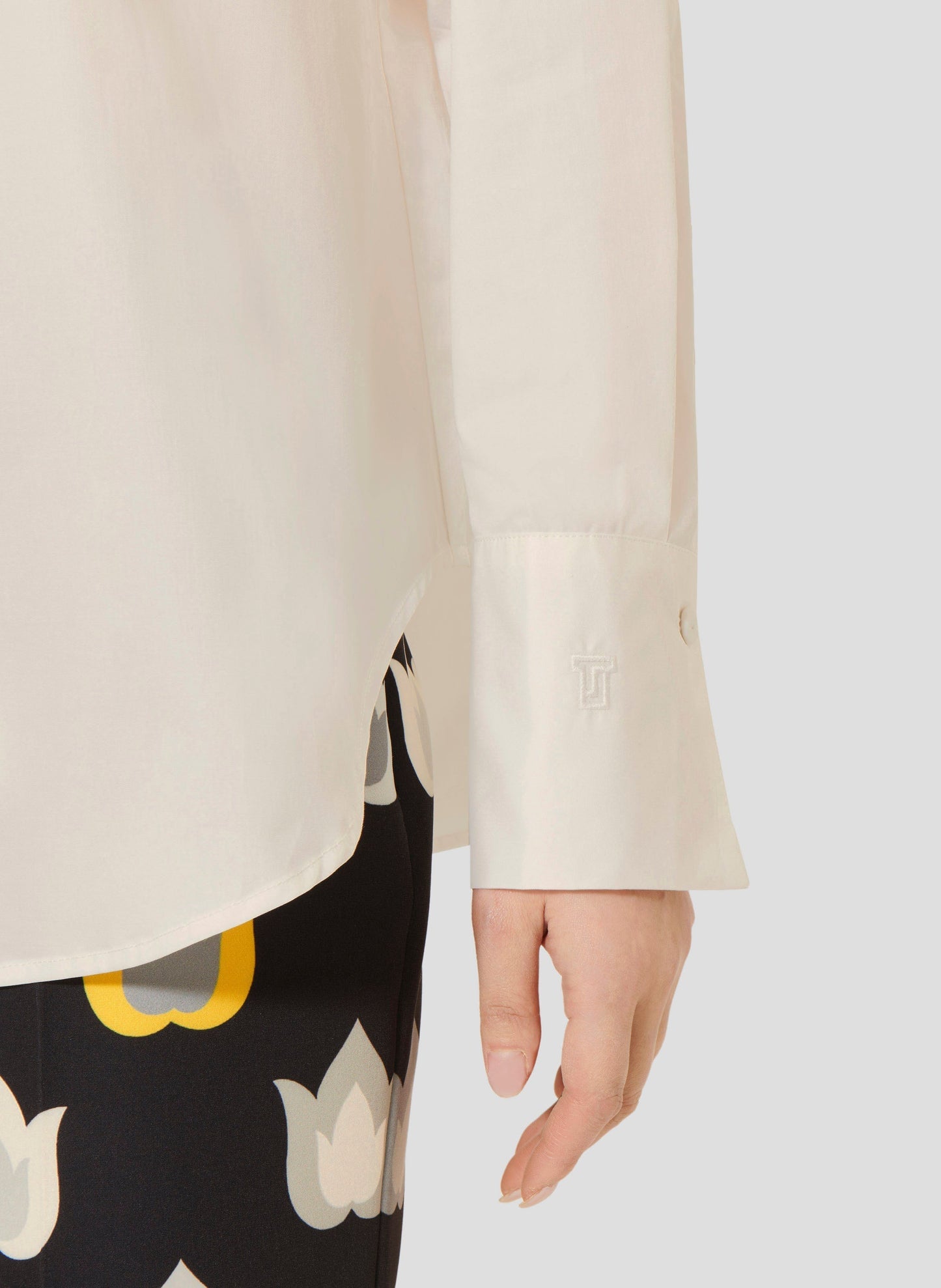 Women's white cotton poplin long sleeves shirt with buttoned cuffs.
