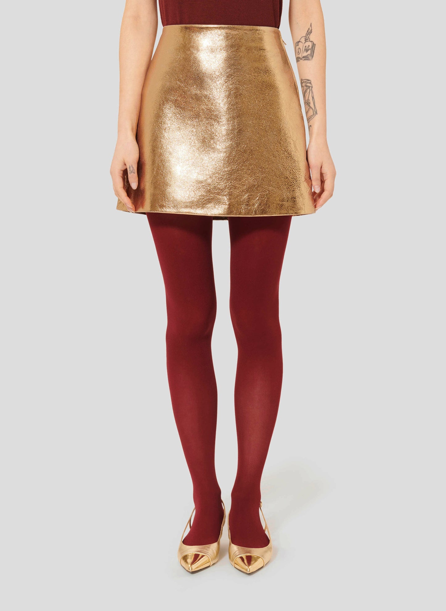 Gold Leather Mini Skirt with Trapeze Shape and Hidden Zip with Red Tights.