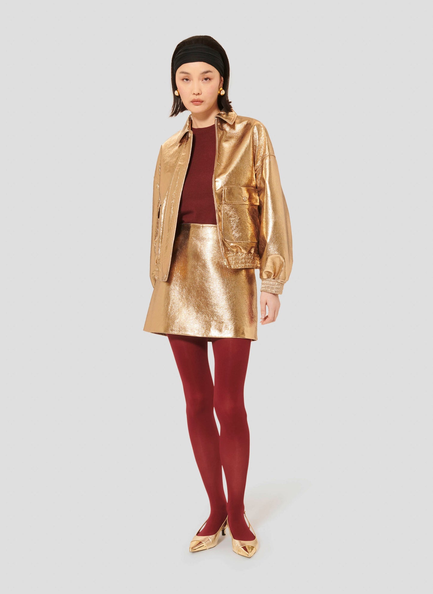 Stylish Gold Mini Skirt with Leather Finish and Invisible Closure Matching with Golden Leather Jacket.