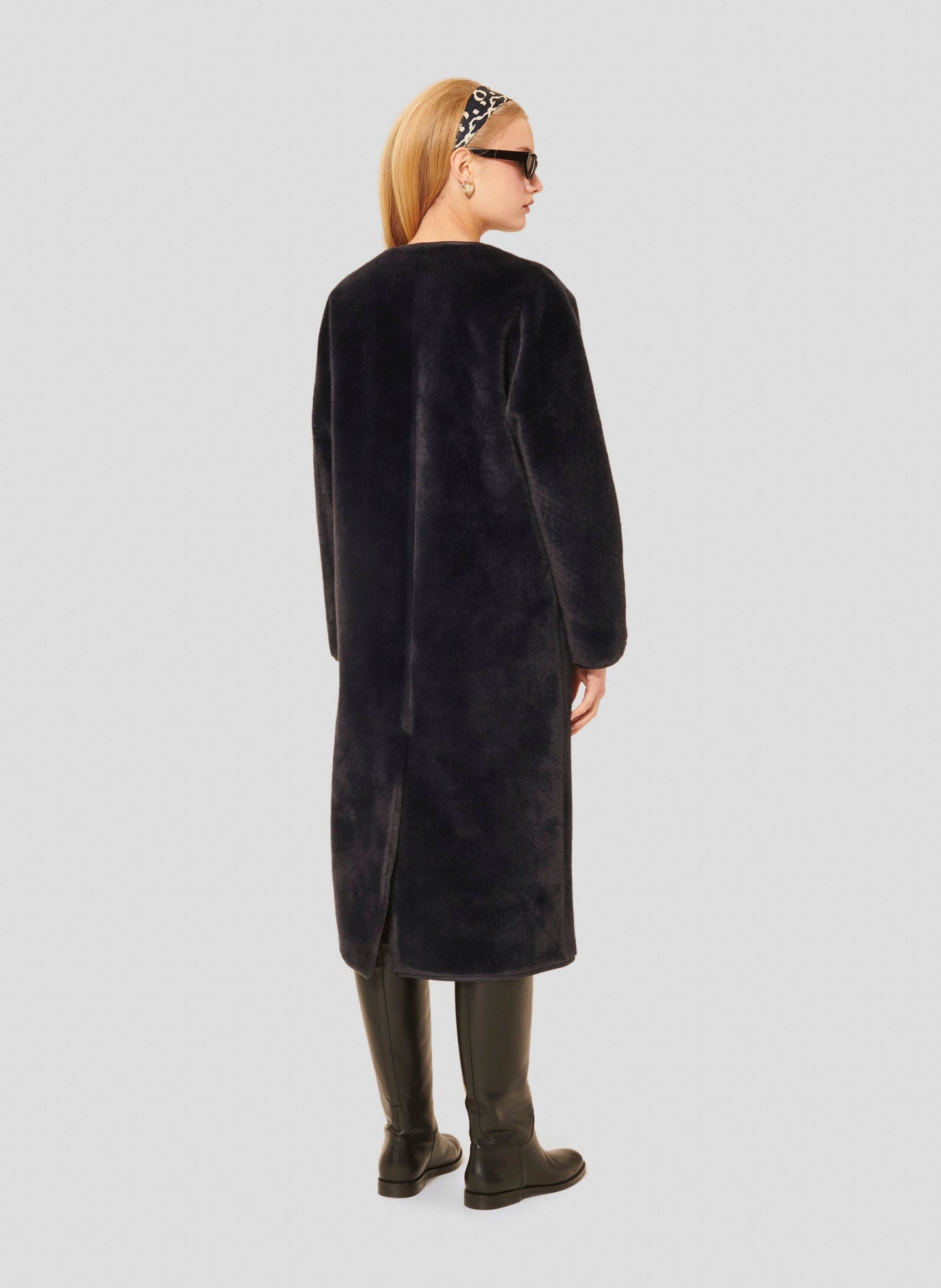 Tara Jarmon model wearing long midnight blue faux fur coat.