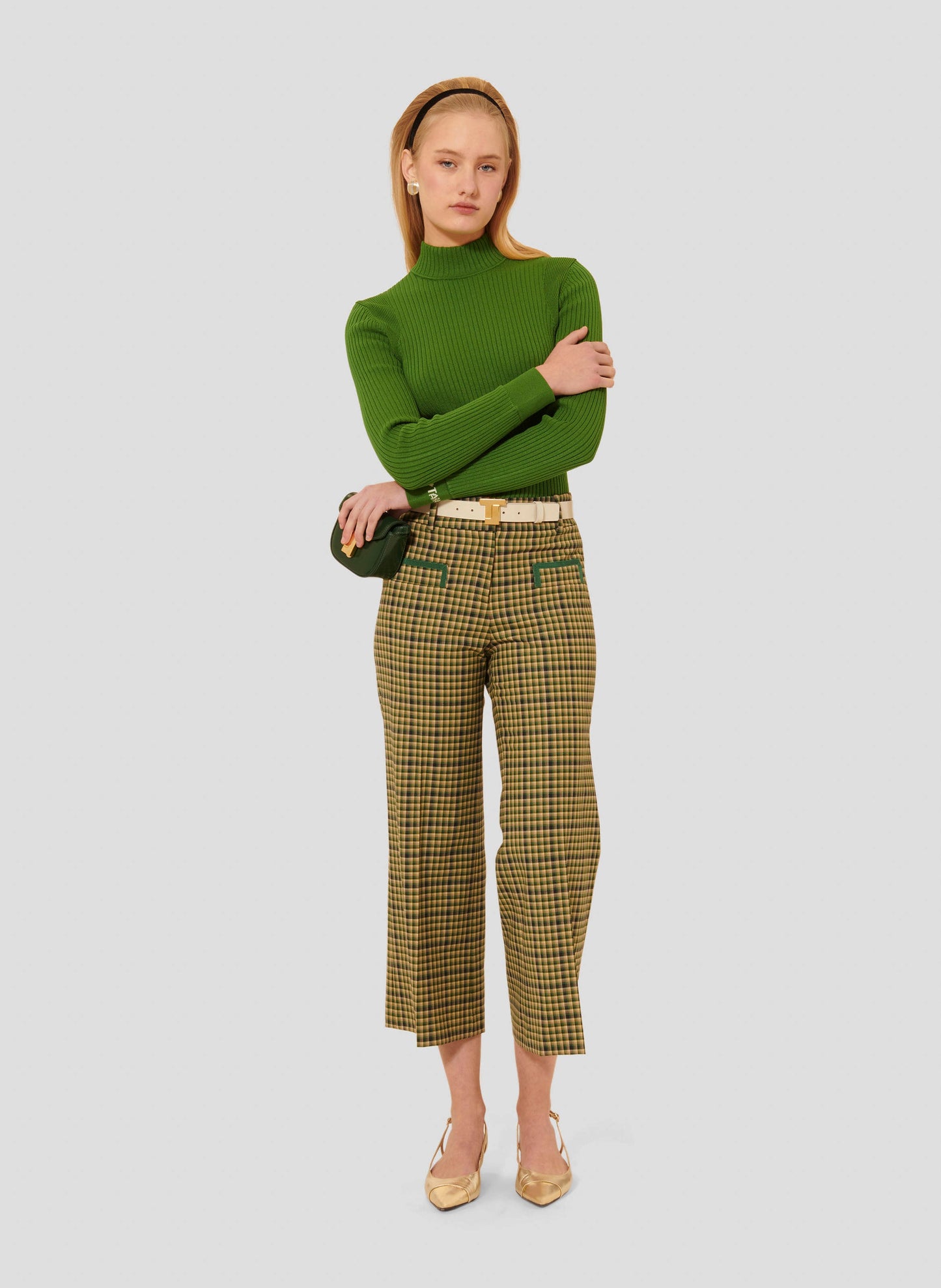 Model wearing Tara Jarmon Mid-Rise Pants in Green Tartan with Two Piped Side Pockets.