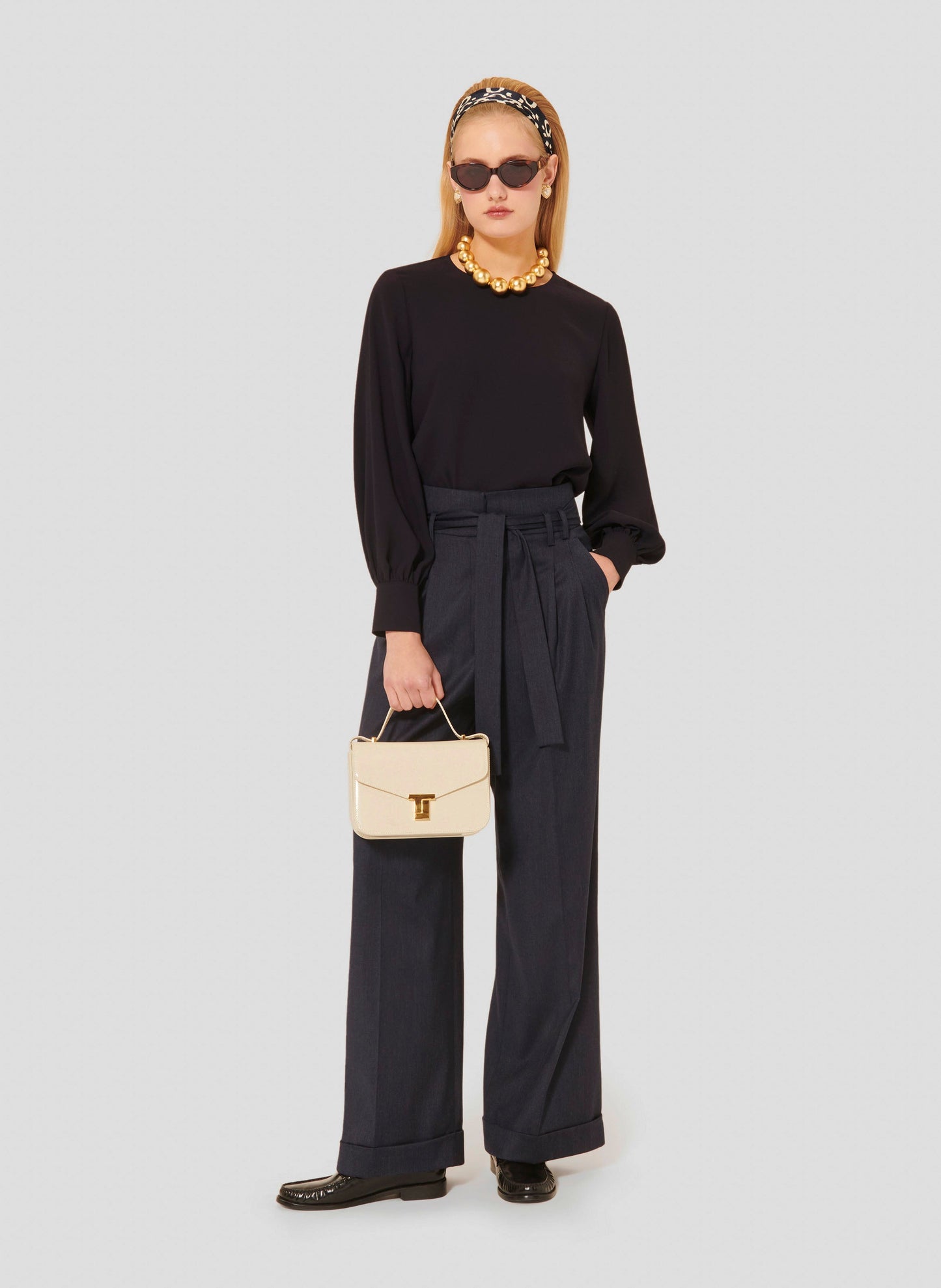 Model wearing Tara Jarmon high-waisted midnight blue wide-leg flannel pants with a belted waist.