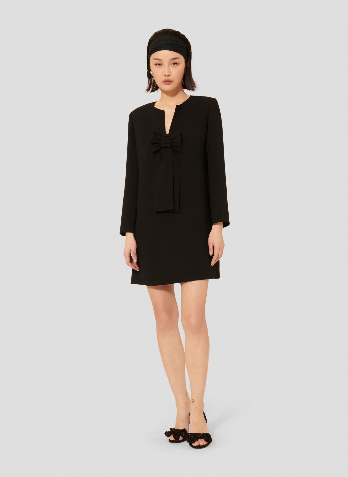 Short black crepe dress with long sleeves and V neckline.