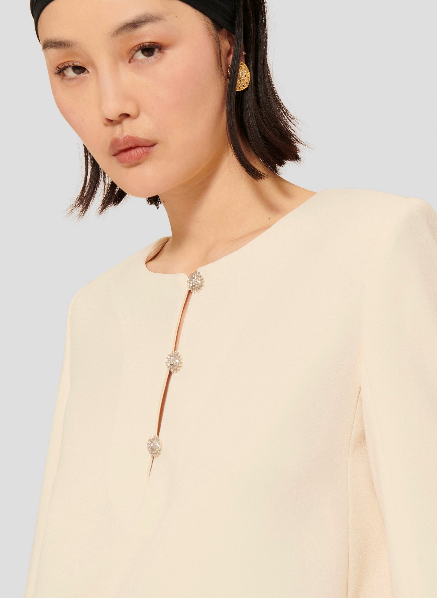 Long sleeves ecru dress with round neckline and jeweled buttons.