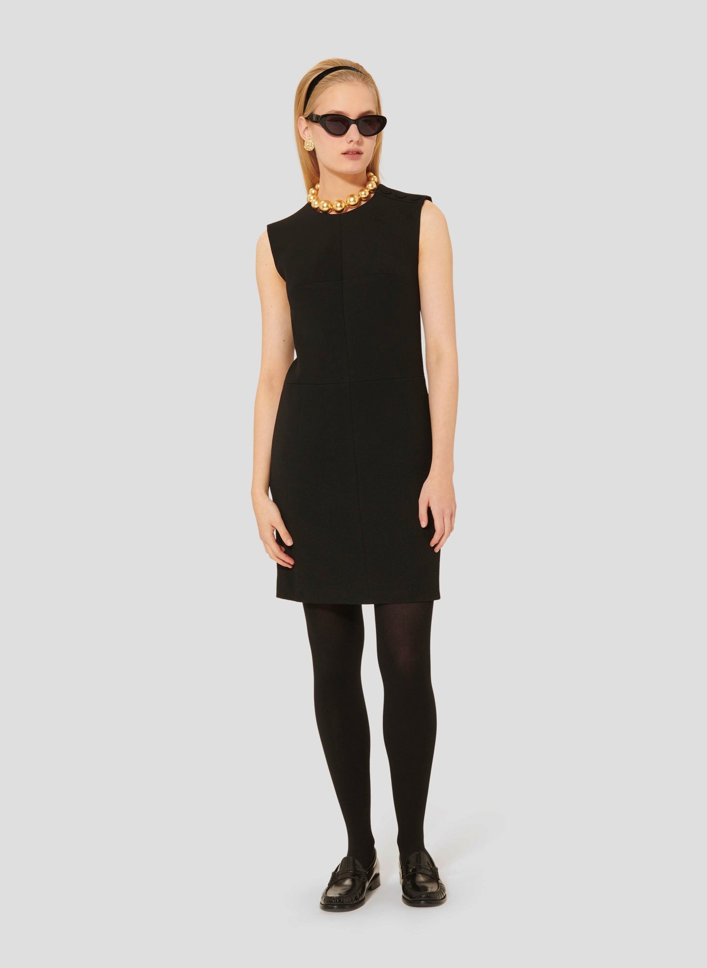 Black sleeveless short crepe dress with round neckline.