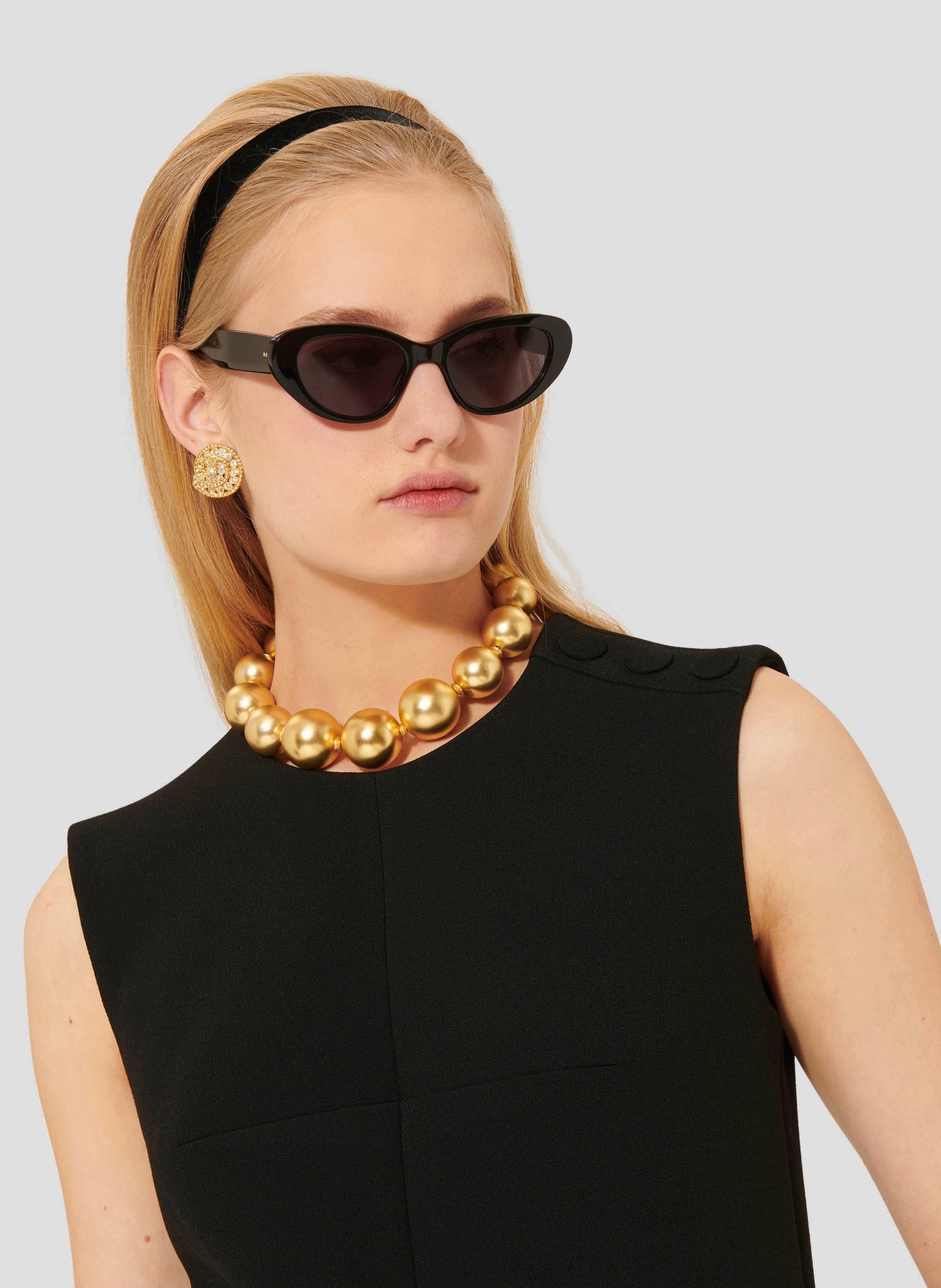 Short black crepe dress decorated with black covered buttons.