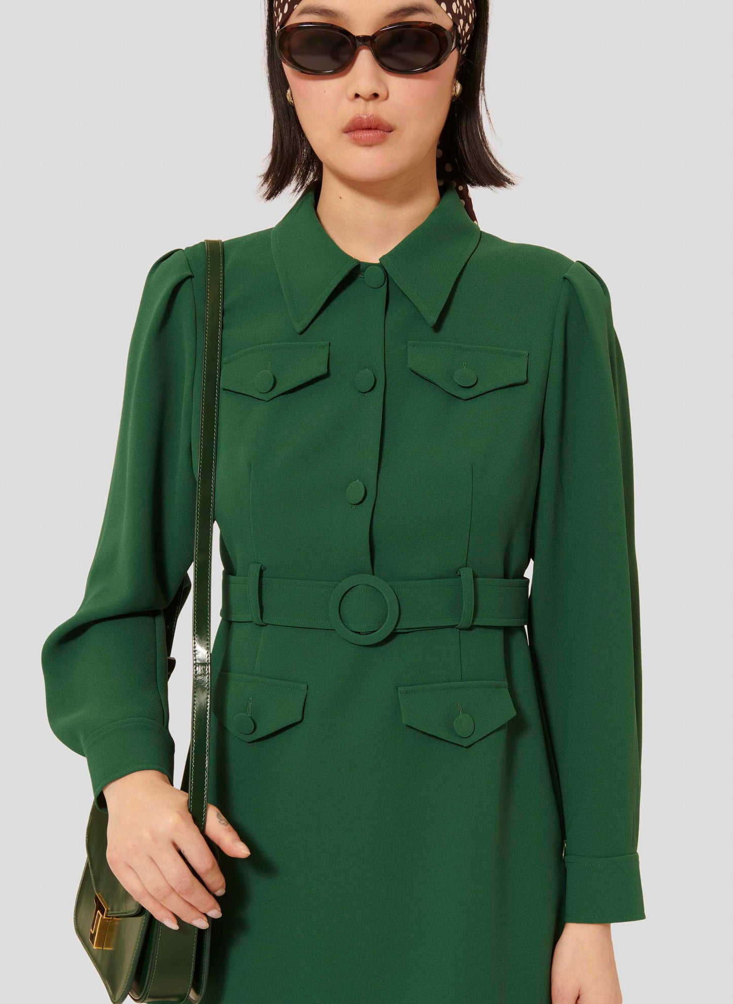 Short green crepe dress with long balloon sleeves and a flowing skirt.