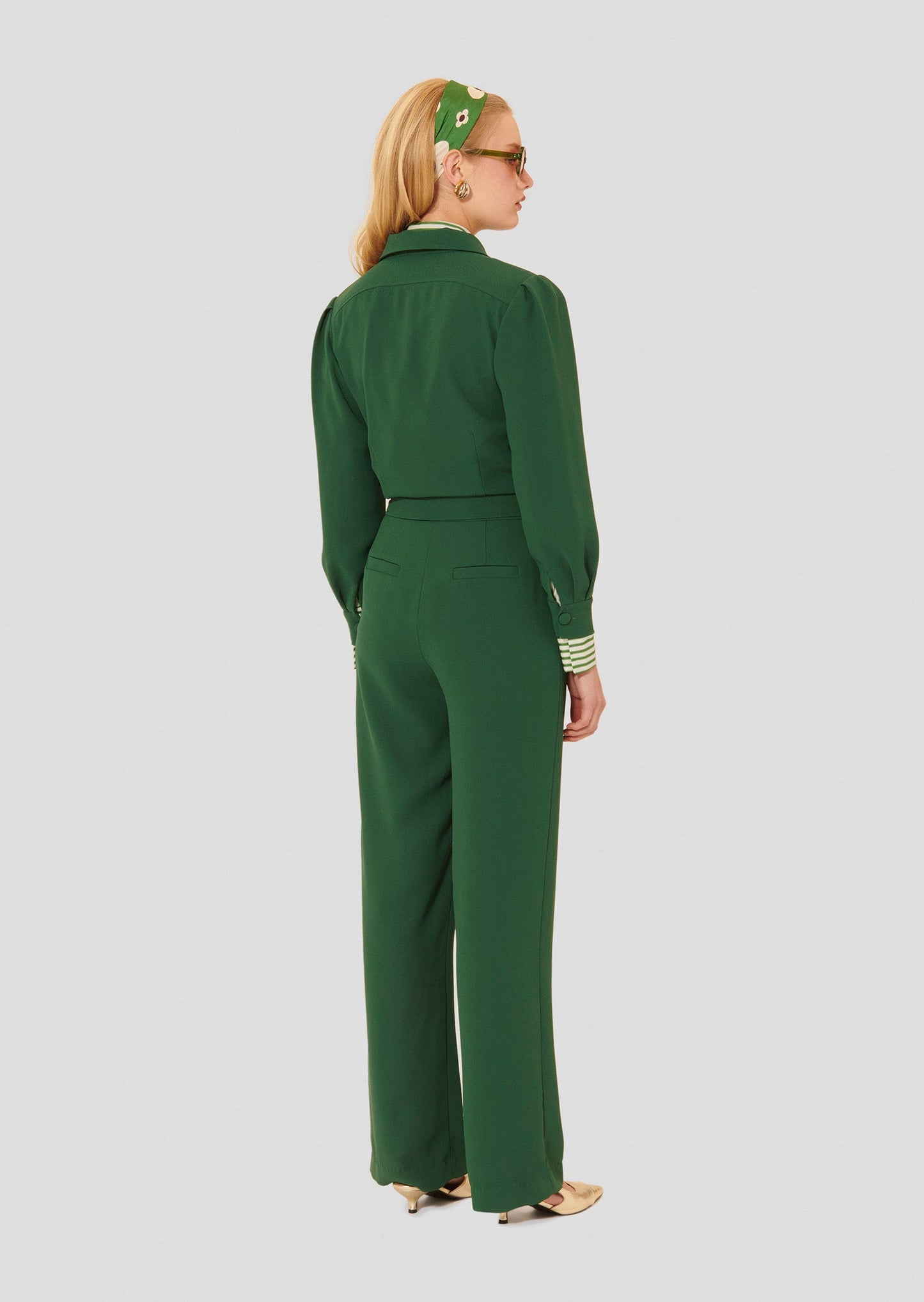 Green crepe jumpsuit with adjustable belt waist.