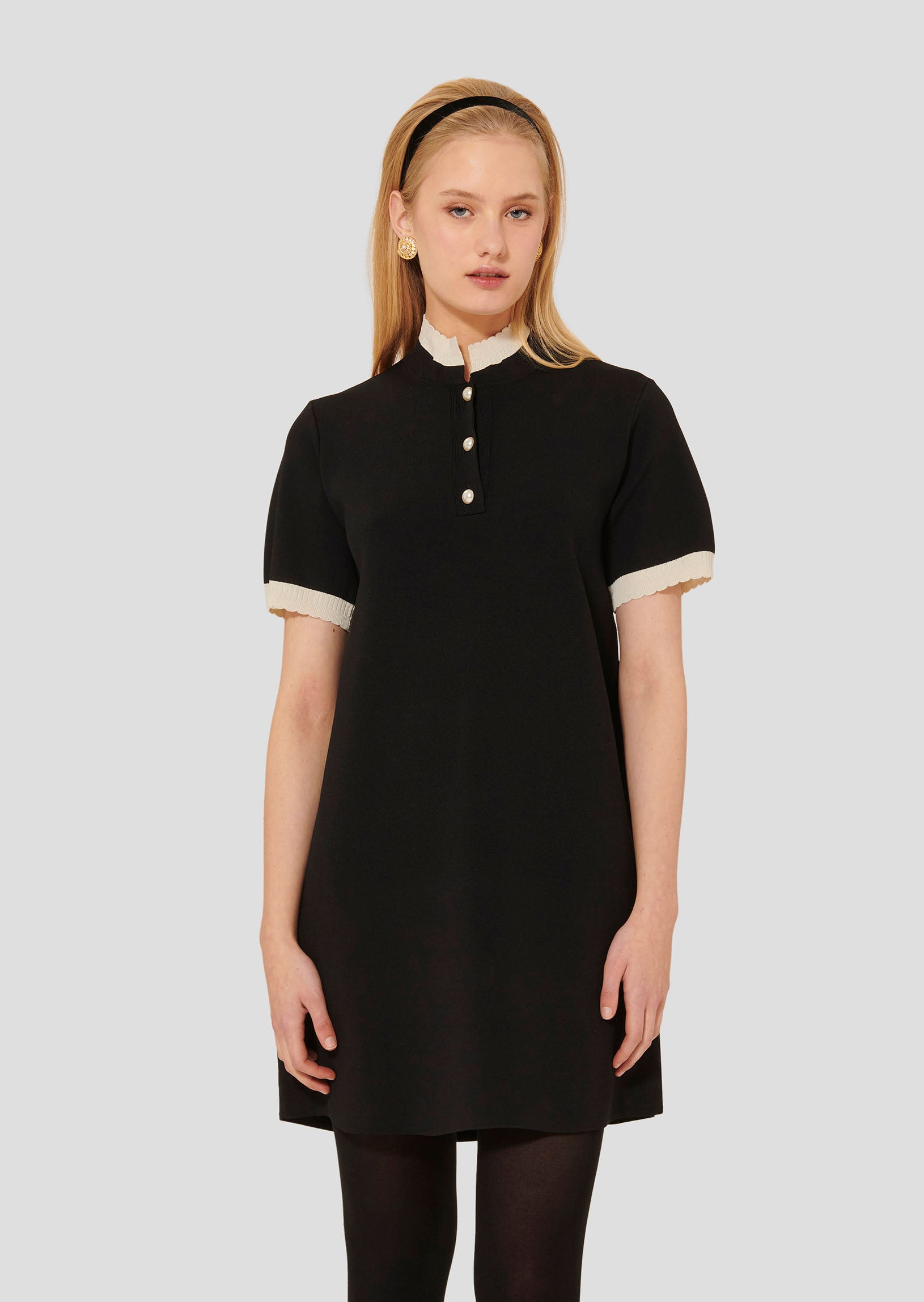 Model wearing Tara Jarmon short black knitted dress.