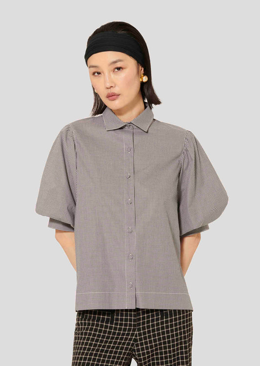 Model wearing Tara Jarmon  black poplin gingham shirt with shirt collar and short puffed sleeves.
