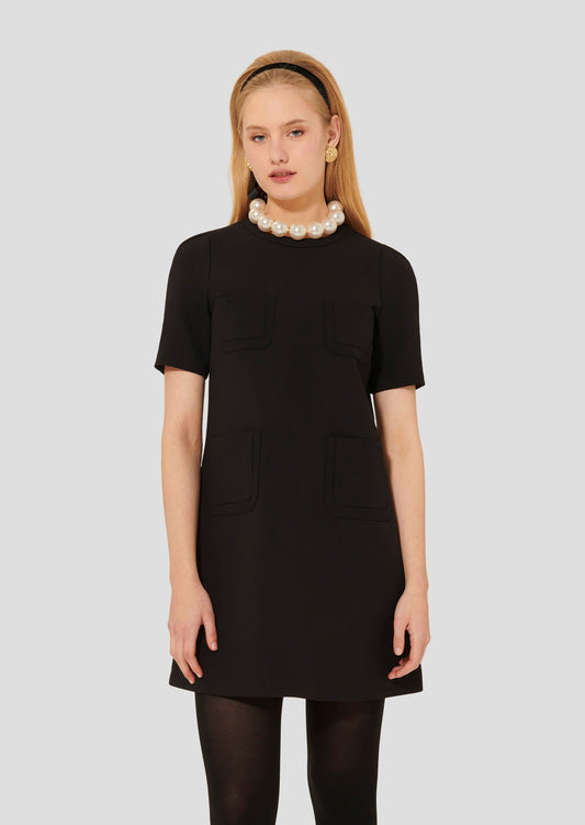 Model wearing Tara Jarmon short sleeves black dress with pockets on the side.