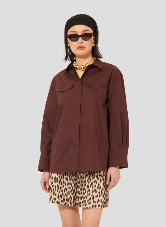 Model wearing Tara Jarmon cotton burgundy poplin shirt.