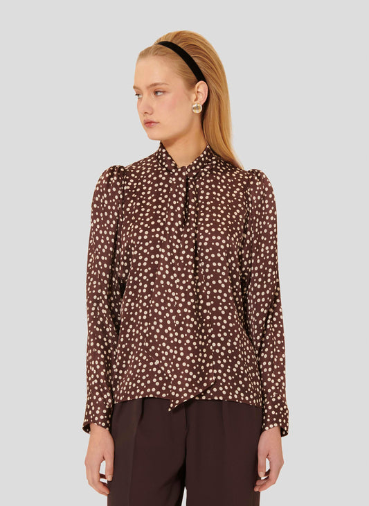 Model wearing brown chocolate shirt with white polka dots. 