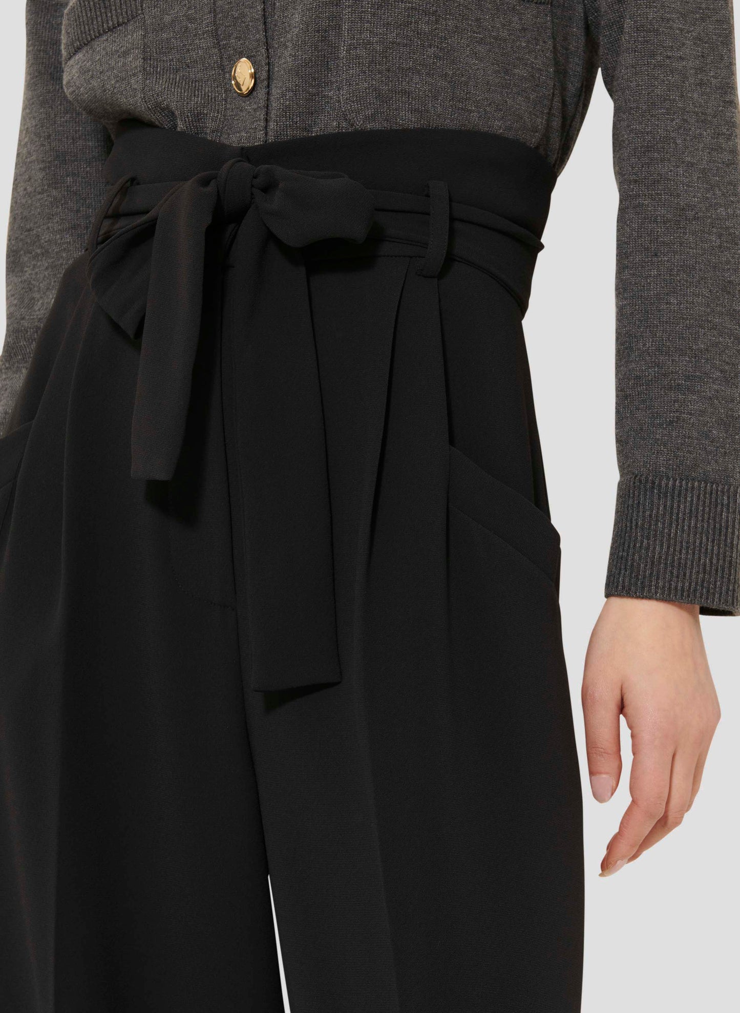 High-waist black wide-leg flannel pants with a belted waist, side pockets, and cuffed hems. Elegant and versatile.