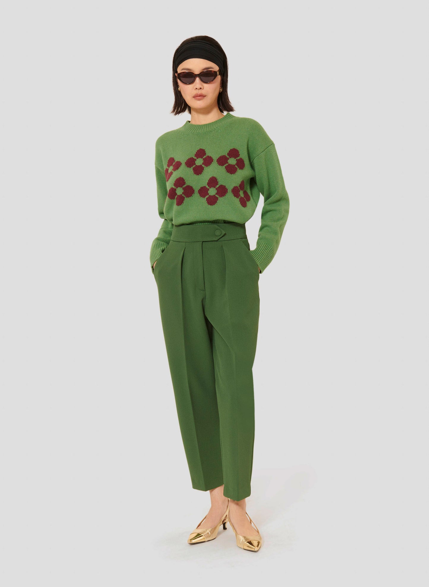 Tara Jarmon model wearing green crepe pants, with a light green sweater.