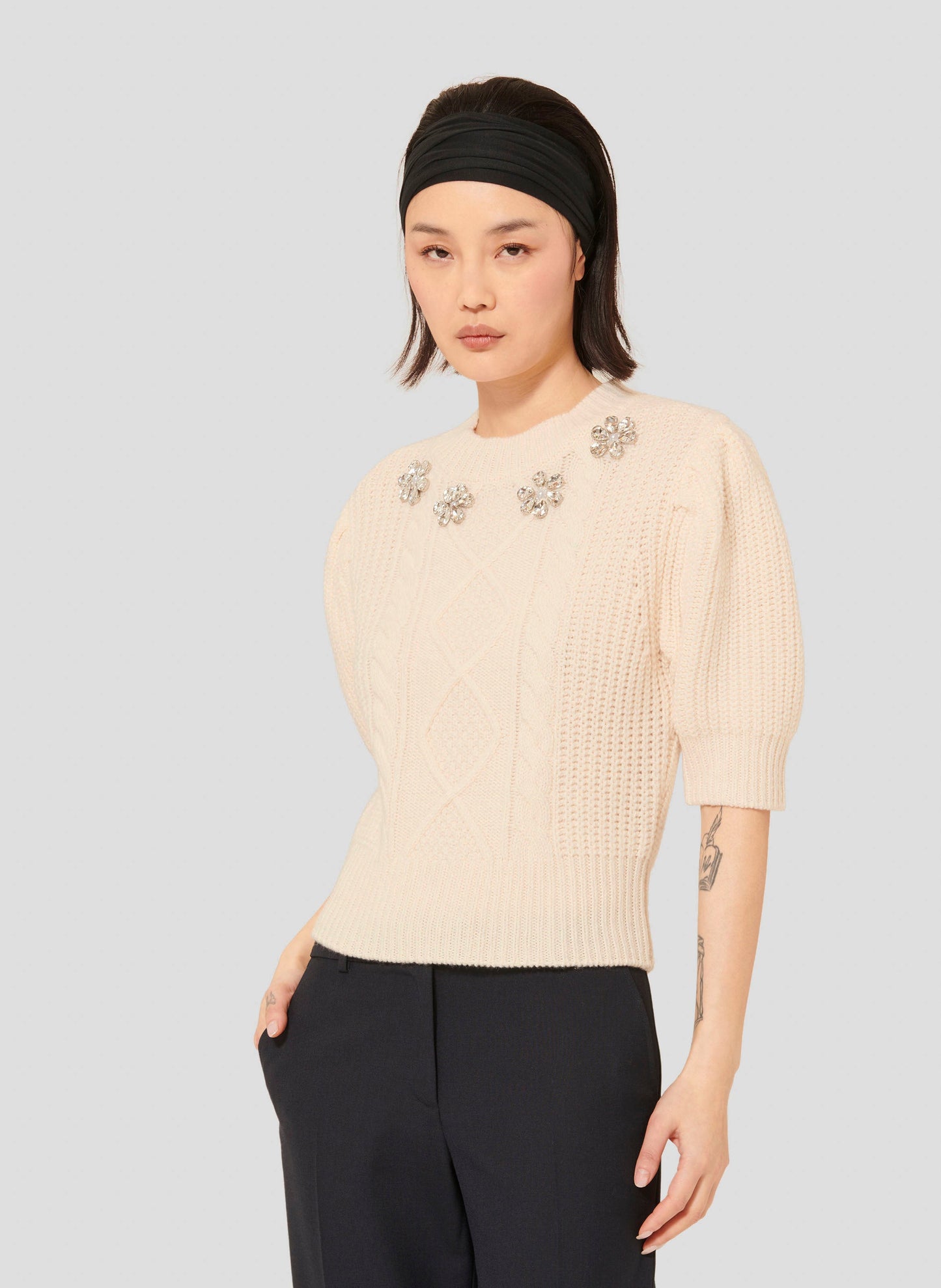 Model wearing Tara Jarmon Women's Off-White Sweater with Embroidered Floral Detail.