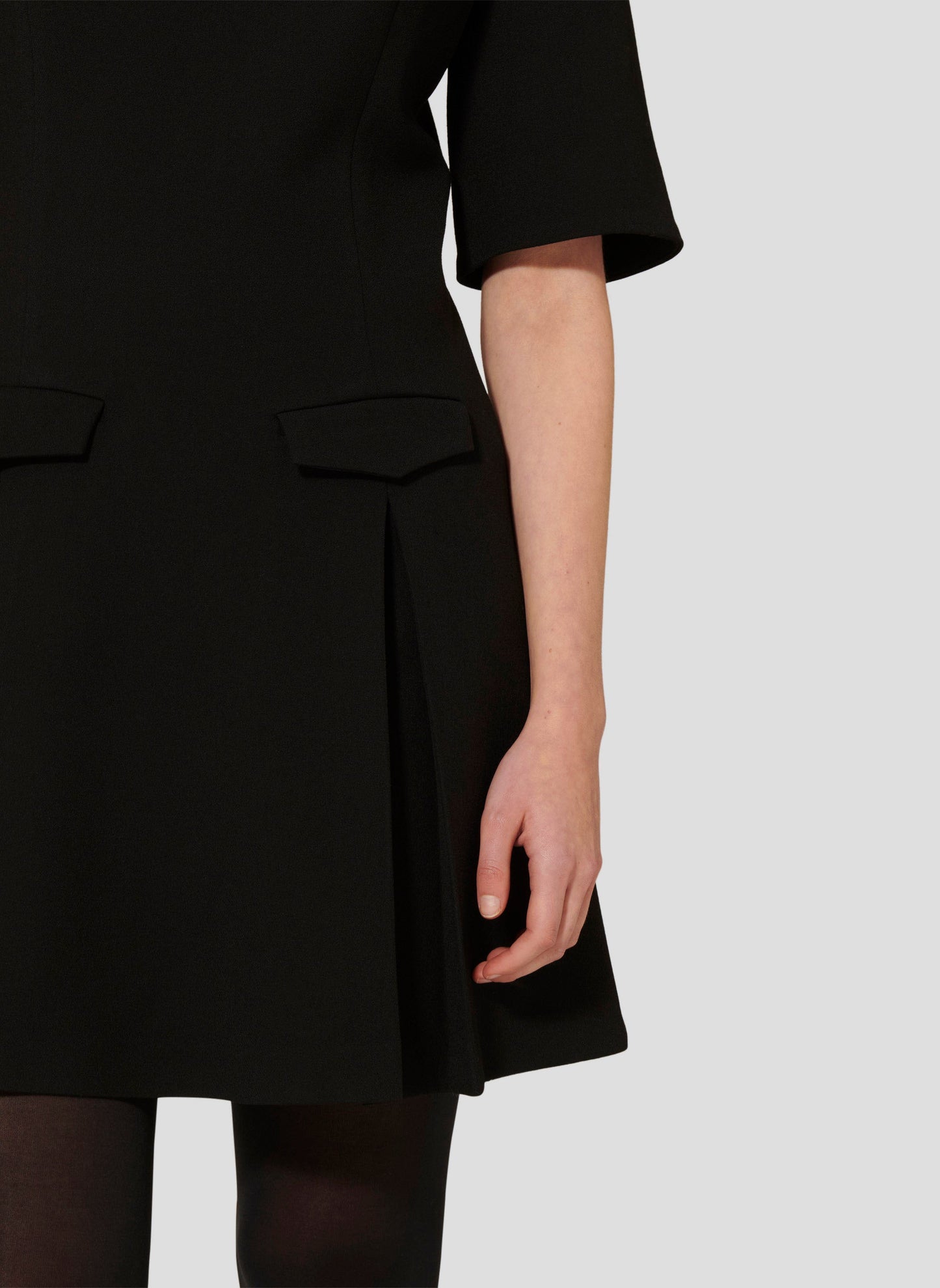 Short Black Dress with Flared Silhouette and Pleated Skirt.